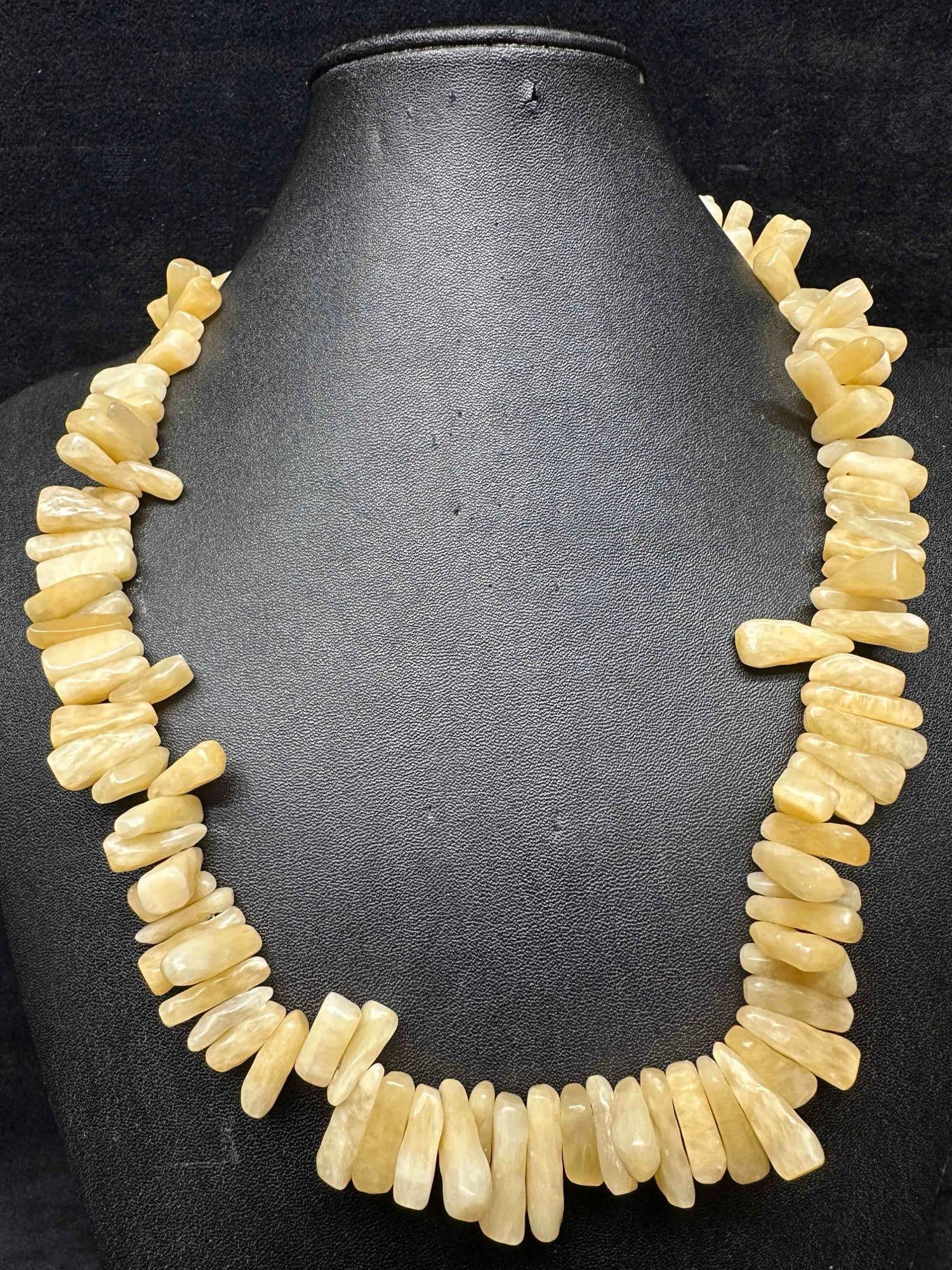 White Shell Coral Style Designed Beaded Long Necklace G51: White Shell Coral Style Designed Beaded Necklace G51. Necklace with cream and white colored beads. The necklace features a lobster claw clasp closure. This item is in good pre-owned, previously