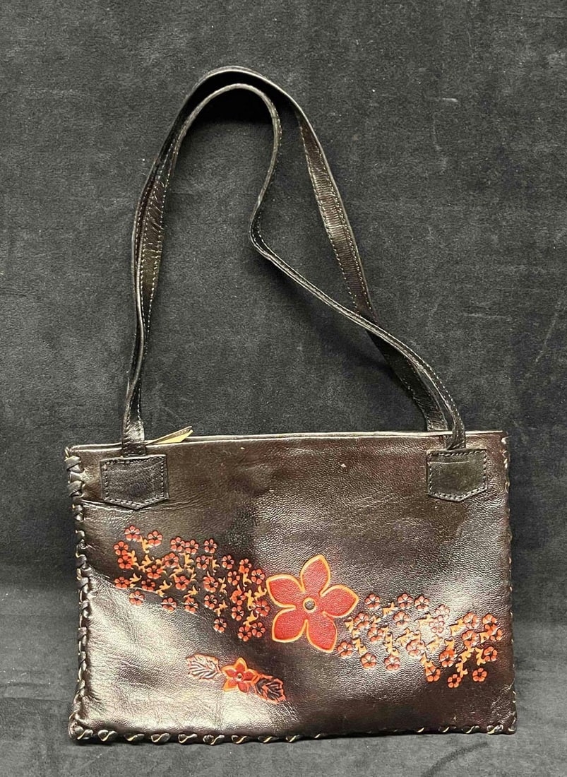Vintage Leather Handicraft Purse With Embossed Flowers (12): This lot contains a Vintage Leather Handicraft Purse With Embossed Flowers (12). The bag is hand-stitched and has a very soft leather liner and inside zipper pocket. It is approx 11" x 1/2" x 7" and
