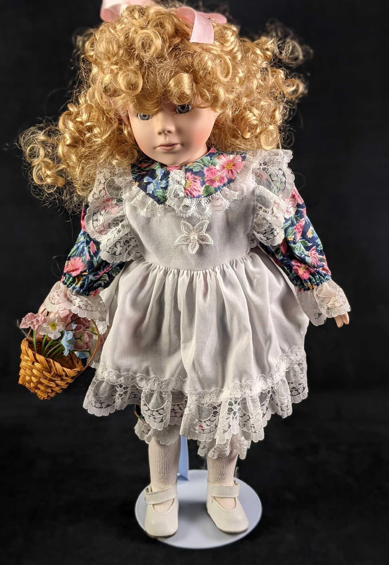 Porcelain Young Curly Hair Blonde Girl With Basket: Porcelain Young Curly Hair Blonde Girl With Basket. Has a porcelain head, neck, hands, and feet. The rest are plush. The maker and date of creation are unknown. Comes with a stand. Doll and stand are