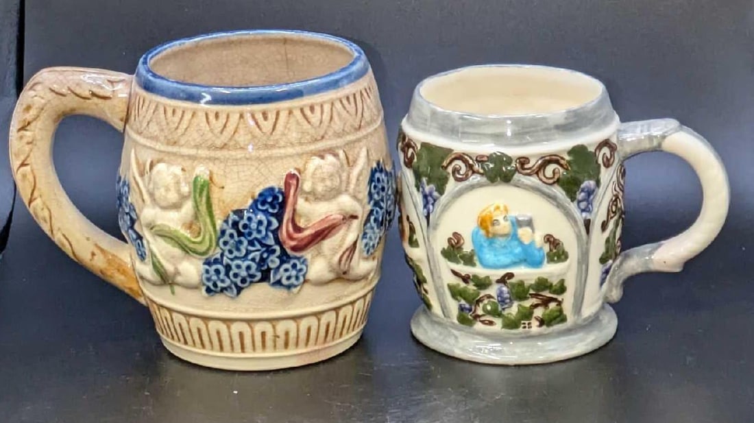 2 Vintage Ceramic Handpainted Mugs: 2 Vintage Ceramic Handpainted Mugs. This lot contains: (1) Ceramic 3D Grapevines Scenes Mug. This is approx 5" x 3 1/2" x 3 1/2".(1) Vintage Ceramic Cherub With Flowers Mug. Made in