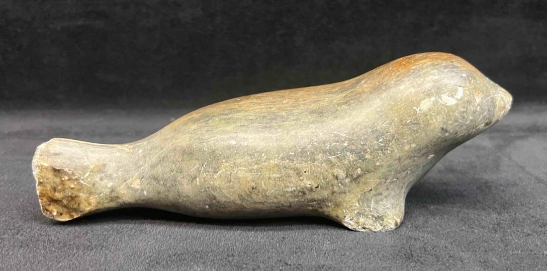 Vintage Hand Carved Inuit Soapstone Seal Figurine: This lot contains a Vintage Hand Carved Inuit Soapstone Seal Figurine. It is approx 6 1/2" x 2 1/2" x 2 1/2". Total weight is 1.1lbs. Overall the Figurine is in good pre owned condition with some