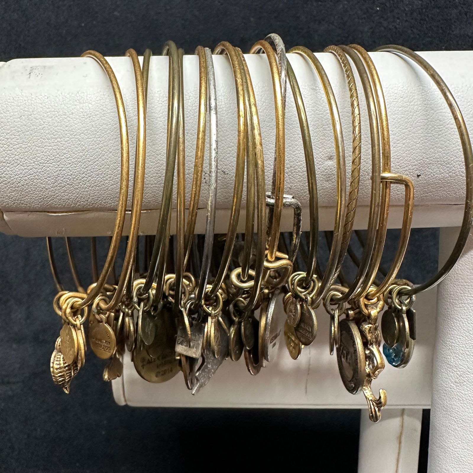 Large Collection of Alex and Ani Expandable Charm Bracelets Mixed Designs: A group of Alex and Ani expandable wire charm bracelets, featuring a variety of popular symbolic and themed designs. The assortment includes mixed-tone finishes such as gold-tone and silver-tone, with