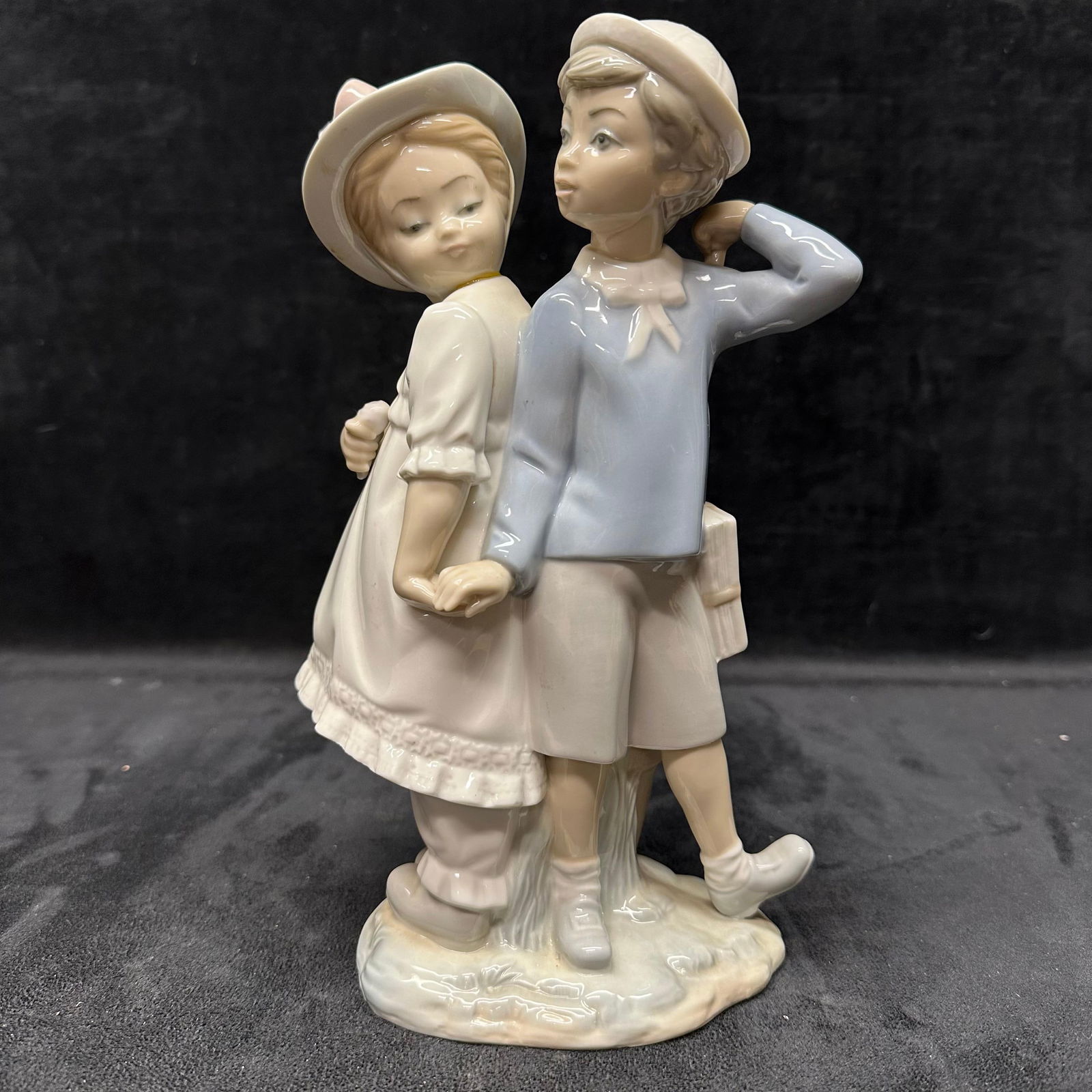 Lladro Puppy Love Porcelain Figurine Children Holding Hands: Hallmark of the bottom of the figure. The girl's head is broken, repaired piece, with a broken/repaired area showing light glue residue. Light markings under the bottom of the figure. This item is