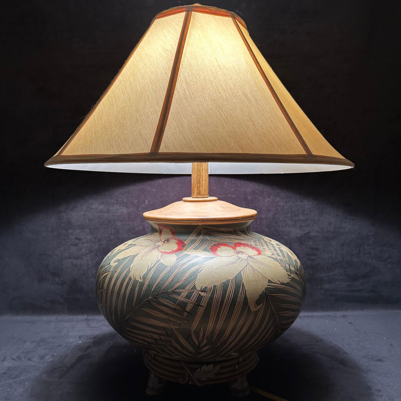 Tropical Botanical Pottery Vase Style Table Lamp: Large decorative table lamp with a hand-painted tropical floral motif on a bulbous ceramic-style base. Features palm fronds, orchids, and botanical detailing in muted greens, tans, and red accents. Th