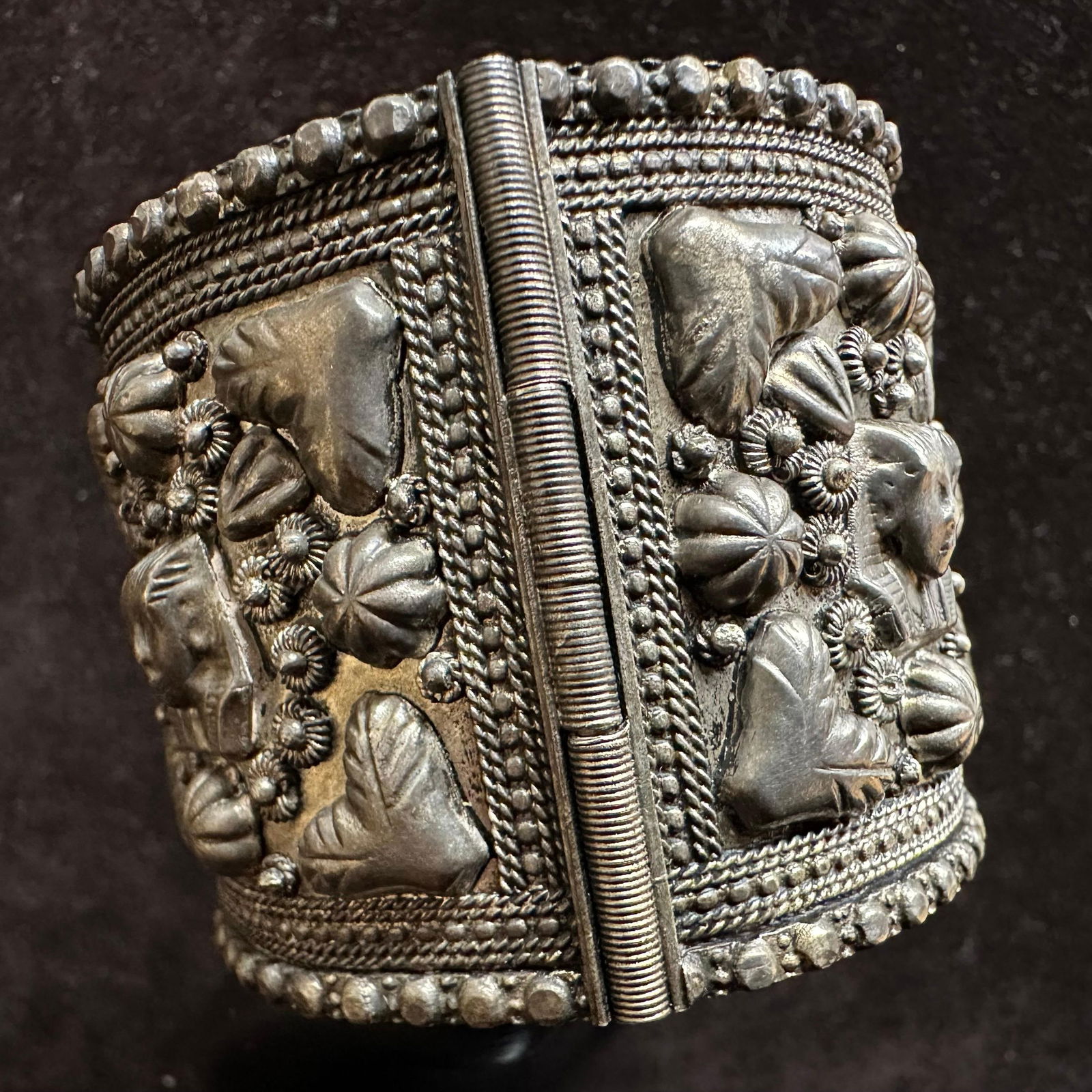 Silver Plated Vintage Egyptian Revival Tutankhamun Hinged Cuff Bracelet: Large, thick hinged cuff bracelet featuring heavy figural heads, King Tut style, floral clusters, and leaf motifs arranged in repeated panels. The functional side hinge opens for easy wear. Interior