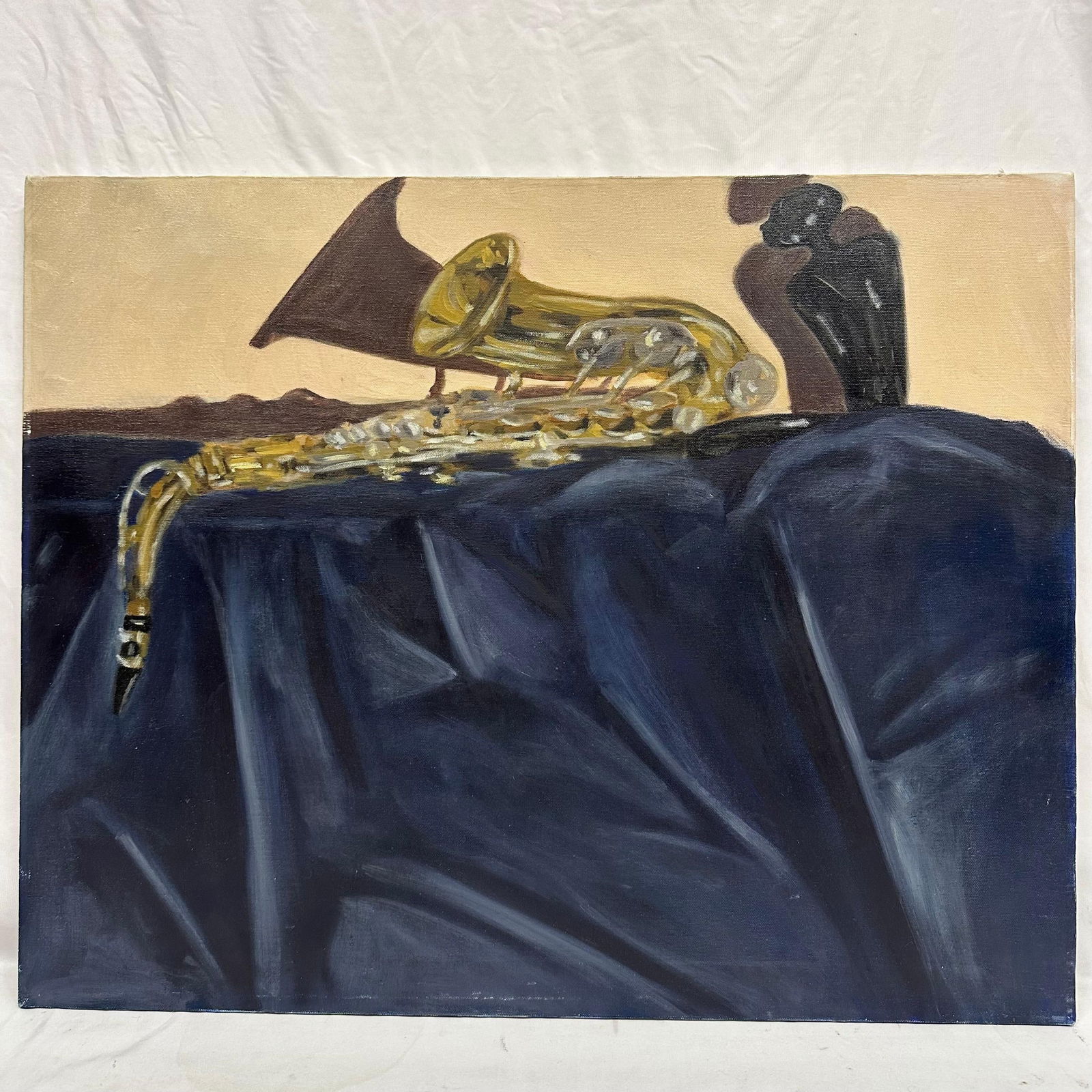 Original Oil Painting Still Life With Saxophone Attributed to Alonzo Adams: Oil on canvas still-life depicting a saxophone resting on draped dark blue fabric with two dark sculptural vessels in the background. Warm neutral tones create contrast against the metallic