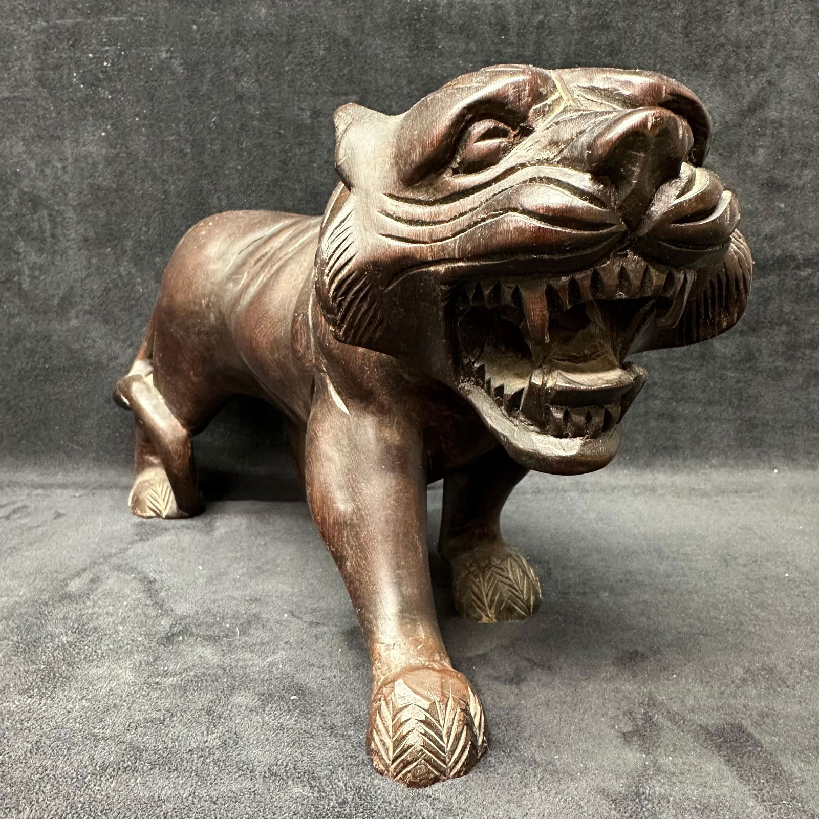 Solid Hand Crafted Wooden Tiger Animal Sculpture: Hand-carved wooden tiger figure with an aggressive stance and an open mouth showing carved teeth. Carved from a single piece of wood with detailed facial features, musculature, and textured paws.