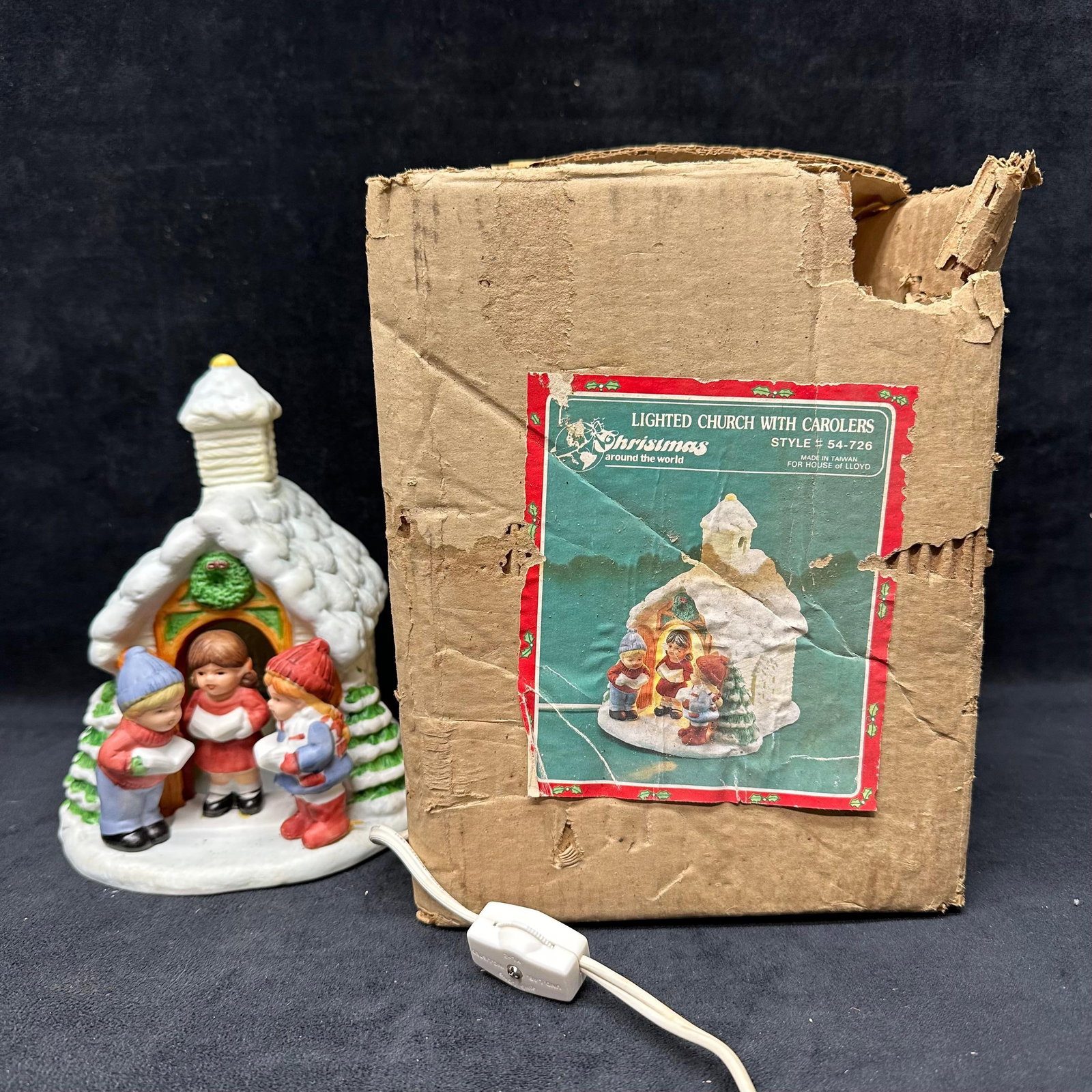 Lighted Ceramic Church with Carolers Christmas Decoration: Vintage ceramic Christmas decoration depicting a snow-covered church with three child carolers at the entrance. Includes original power cord with inline switch. The underside is marked, and the piece