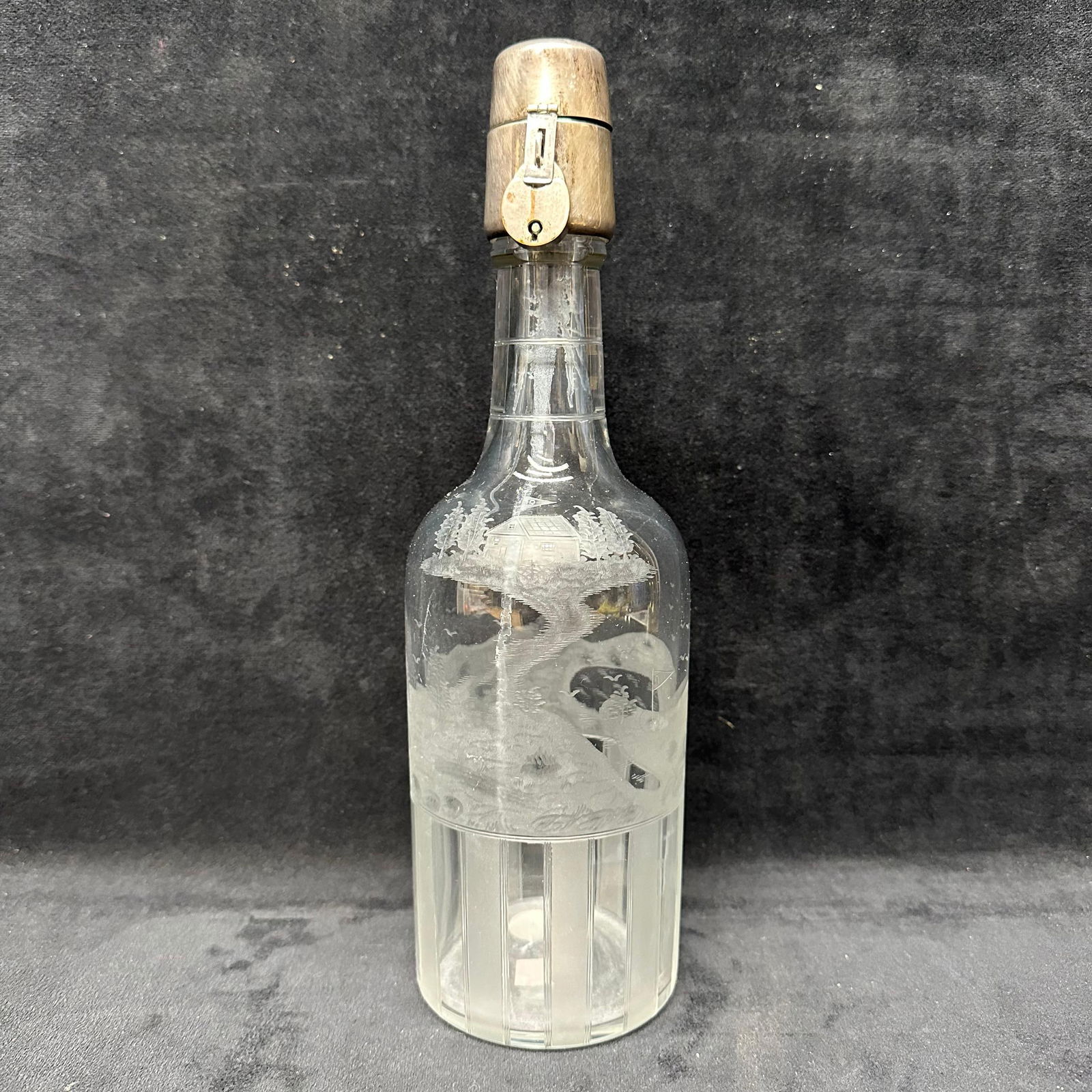 Engraved Glass Decanter with Hawkes Sterling Silver Locking Cap: Antique clear glass decanter featuring detailed acid-etched and engraved decoration, including a rural landscape scene with a house, trees, birds, and a winding path. The lower section displays vertic