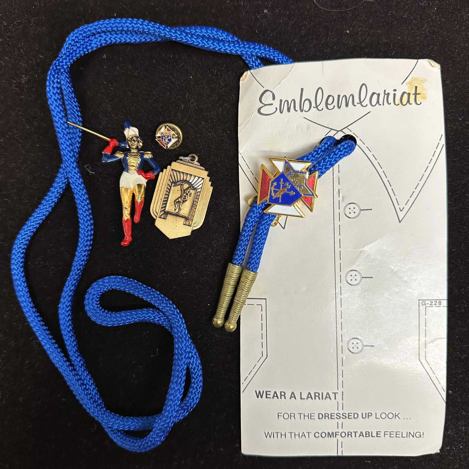 Knights of Columbus K of C Emblem Lariat and Lapel Pin Lot Twirler Medal: A lot of vintage Knights of Columbus (K of C) memorabilia, including an Emblem Lariat bolo-style neck cord, a 1952 Twirler medal, a hand-painted marching band twirler pin, and a small K of C enamel