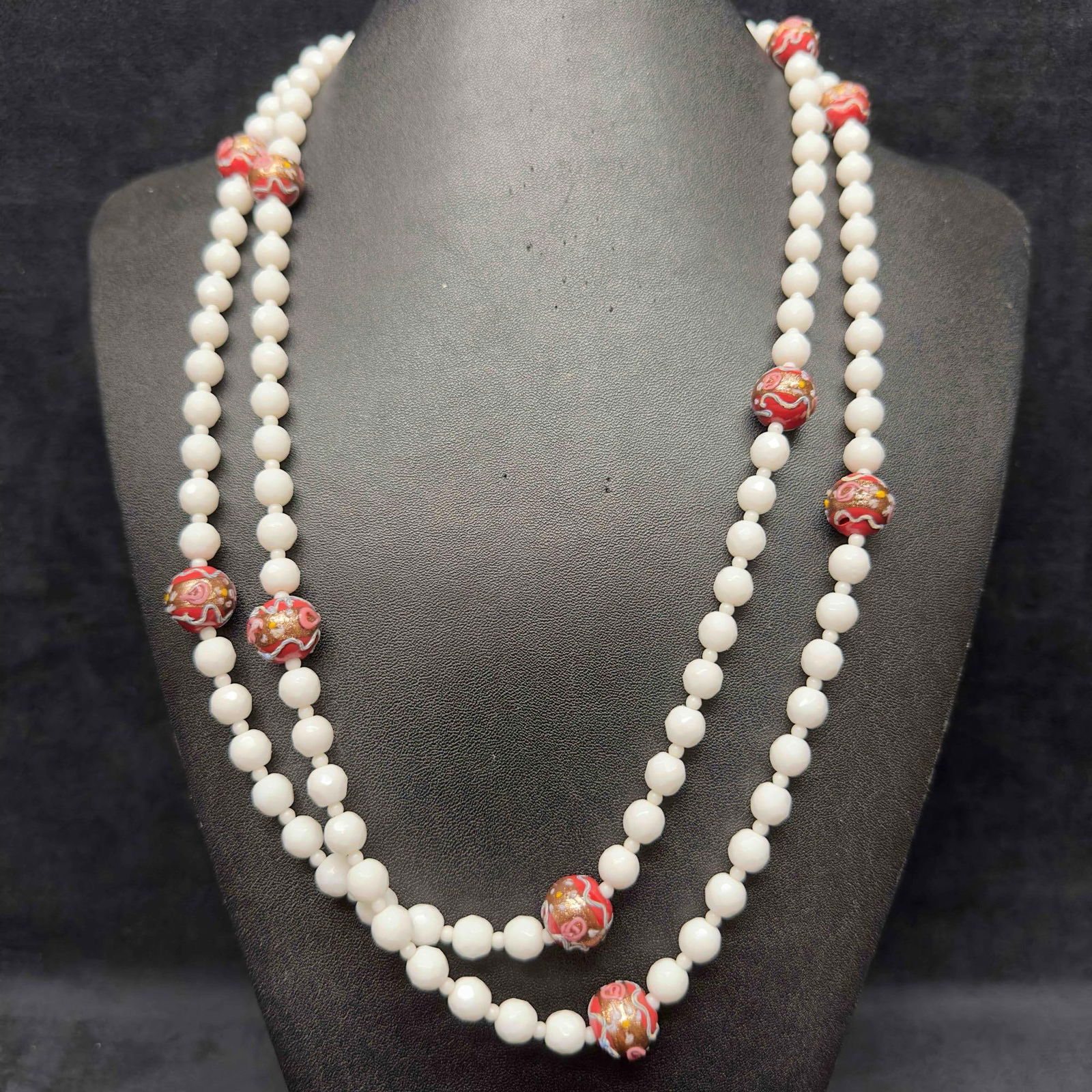 Murano Venetian Lamp Work Art Glass Red and White Beaded Long Necklace C76: Murano Venetian Lamp Work Art Glass Red and White Beaded Long Necklace C76. Necklace with red and white colored glass beads with beautiful designs on each. The necklace features floral accents. The ne