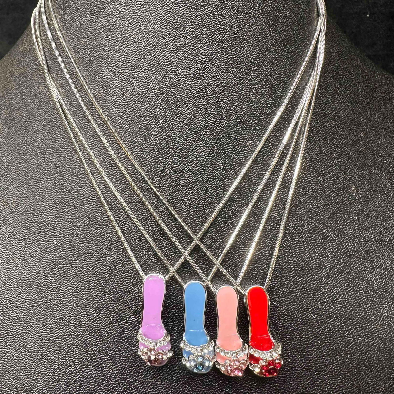 Flower Rhinestone Slipper Show Women's Necklace Set of Four: Four necklace set featuring a floral accent slipper pendant, blue, red, pink, and purple colors represented. These items are in good pre-owned, previously displayed condition with light wear, and surf