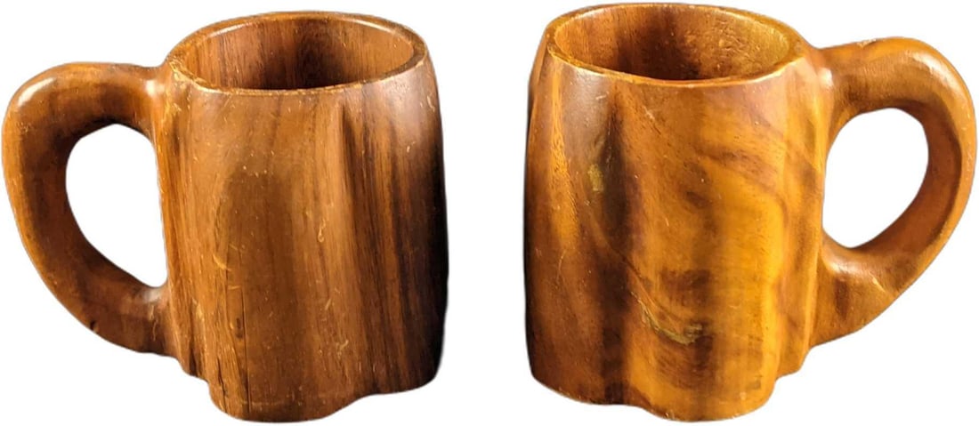 Two Vintage Hand Carved Monkey Pod Steins Mugs: Two Vintage Hand Carved Monkey Pod Steins/Mugs. First mug is approx 6 1/2" x 4 1/2" x 5". The second mug is approx 6 1/4" x 4 3/4" x 5".Together they weigh 2.11lbs. The mugs are in a good, vintage