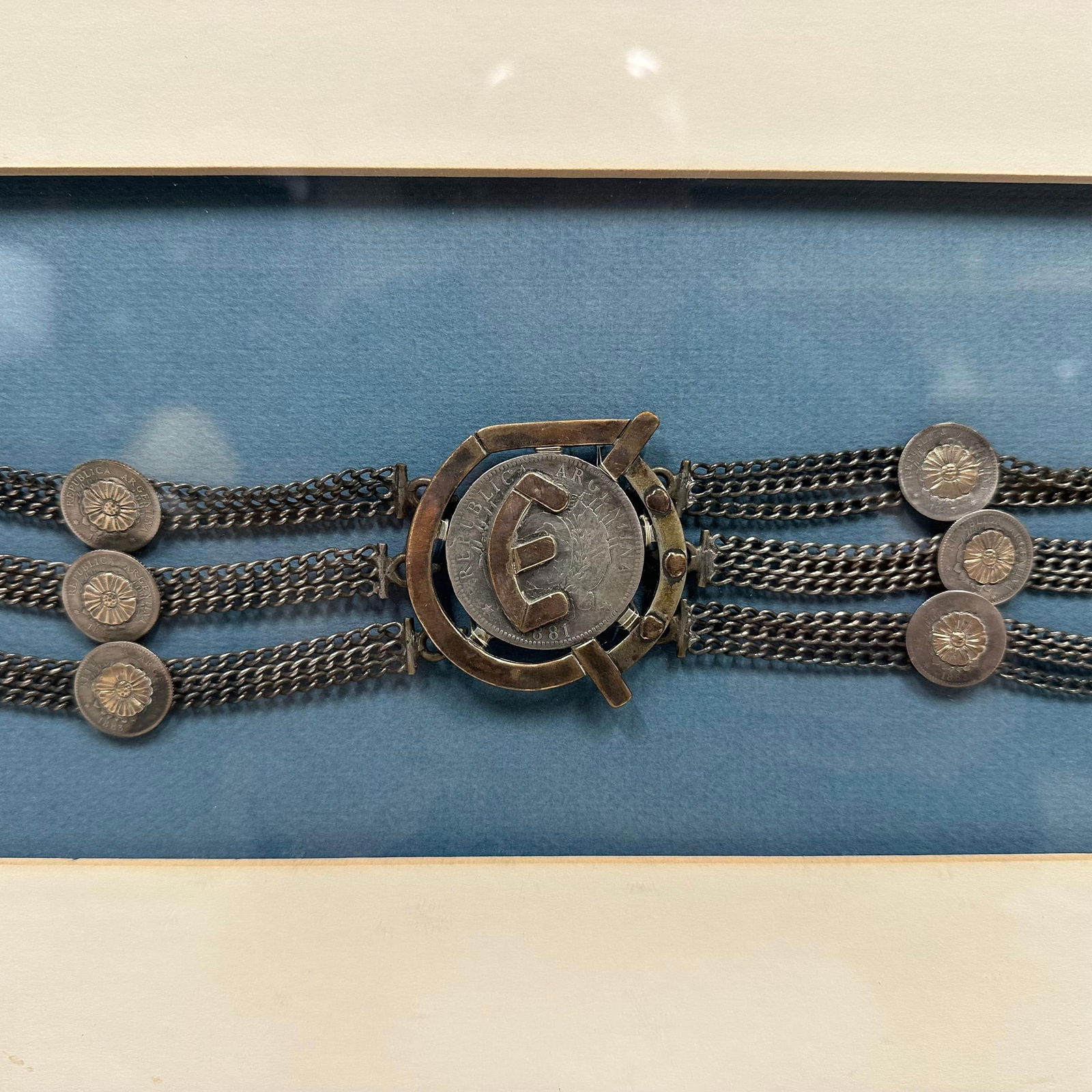 Gaucho Tooled Leather Belt Argentina Silver Coins Concho Center Accent Decor Framed Wall Display: Framed vintage Western-style tooled leather belt featuring floral patterning, concho, and silver coin accents with a central coin medallion marked “Republica Argentina.” Believed to be from