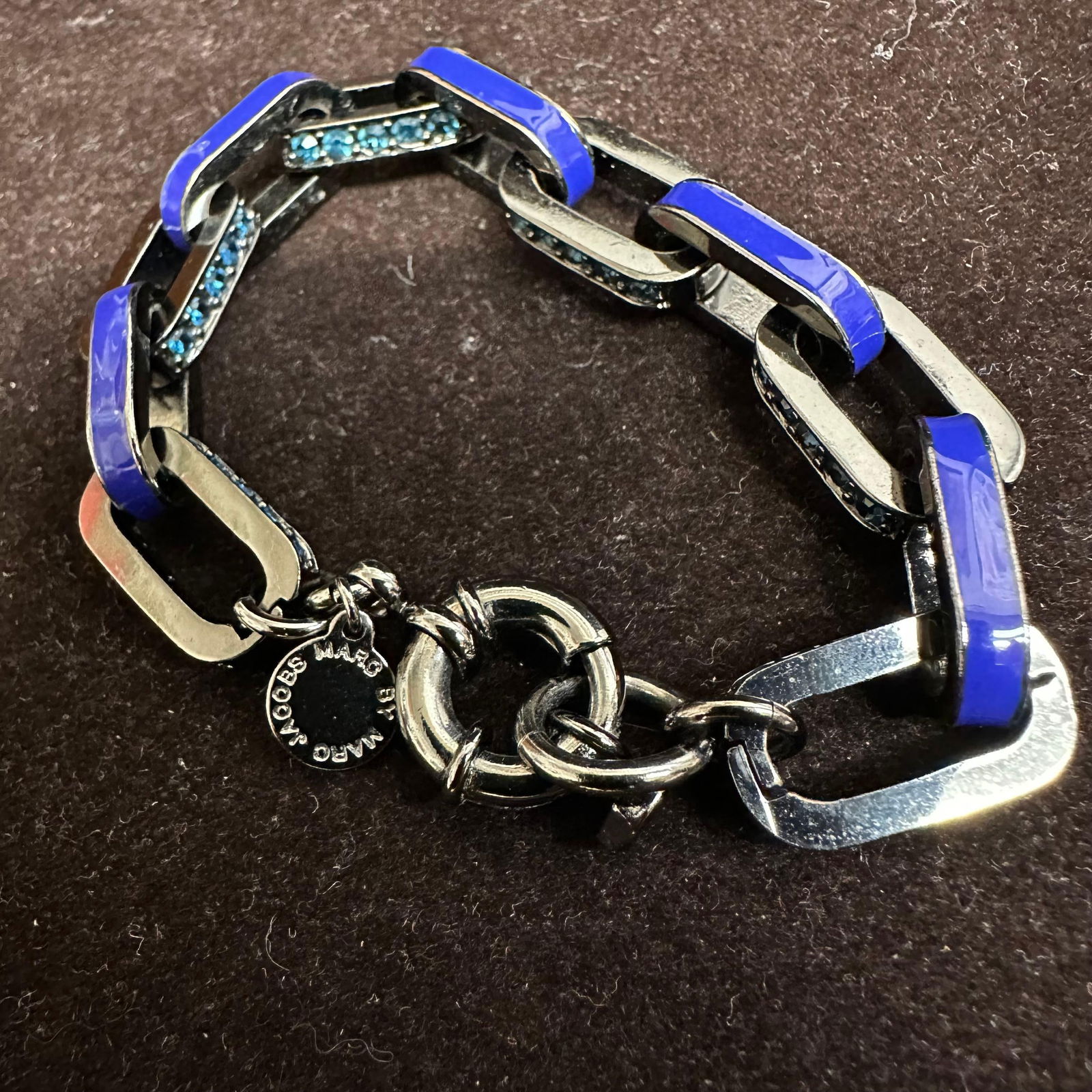 Marc Jacobs Blue Enamel and Crystal Link Bracelet: Designer link bracelet by Marc Jacobs. Features polished gun metal black-tone metal links with cobalt blue enamel accents and inset blue crystals. Finished with a toggle clasp and signature Marc Jacob