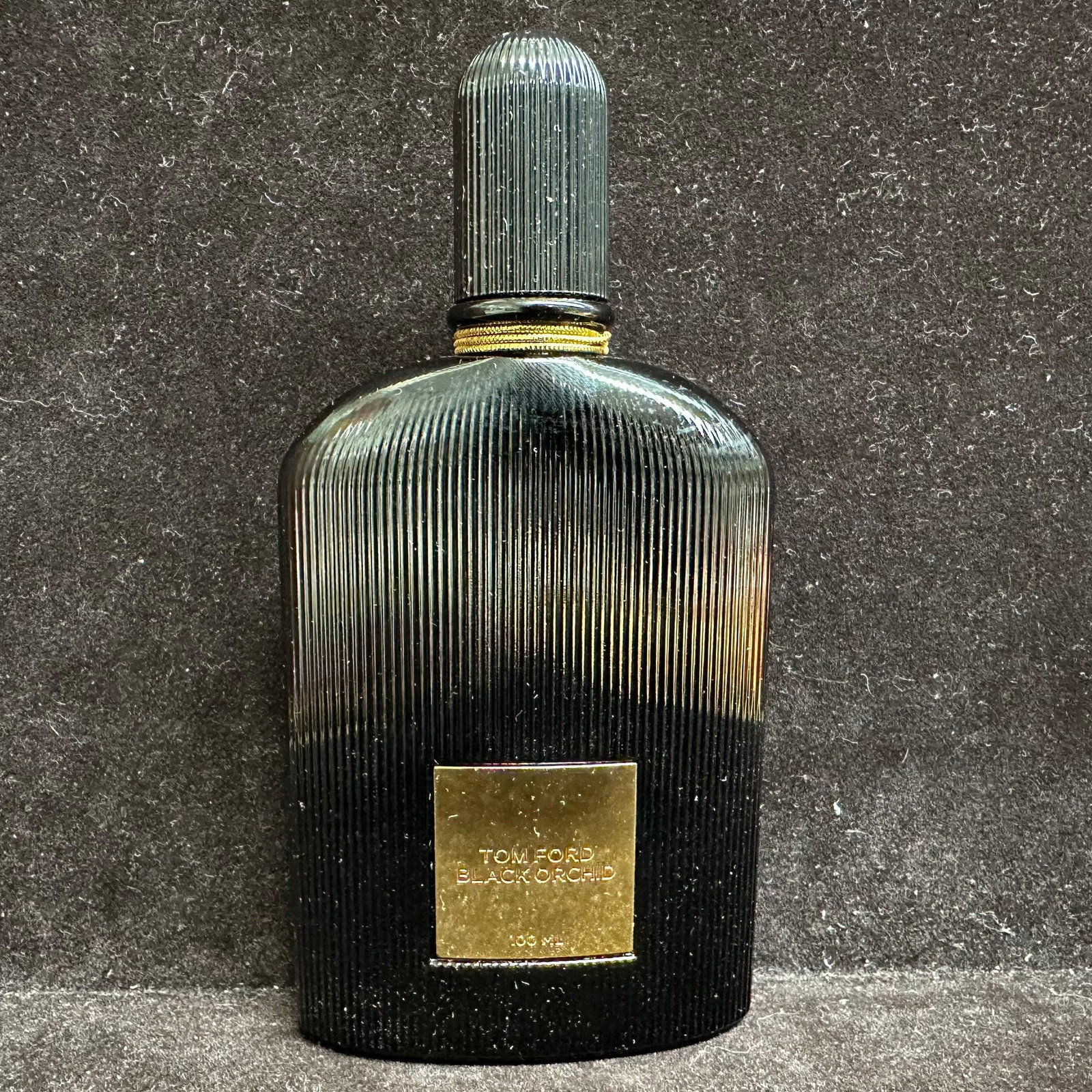 Tom Ford Black Orchid Eau de Parfum 100ml 3.4 fl oz Spray Black Ribbed Bottle: Tom Ford Black Orchid Eau de Parfum in the iconic black ribbed glass bottle with gold-tone plaque. Marked Tom Ford Black Orchid 100 ml. Bottle base reads Eau de Parfum Vaporisateur Spray, 3.4 fl oz /