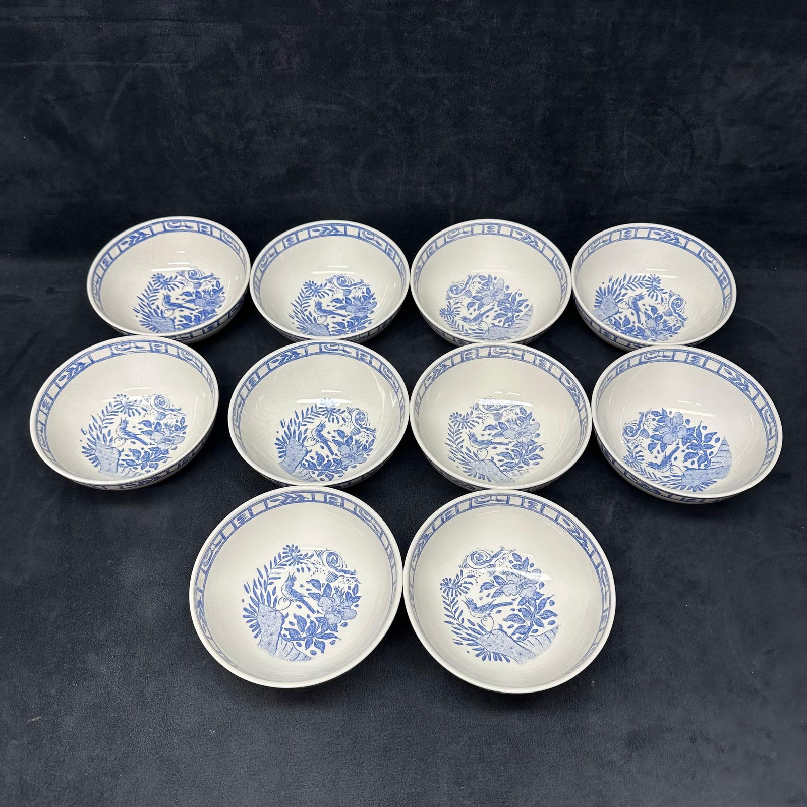 Oiseau Bleu Gien France Blue and White Porcelain Bowls Set of 10: Matching set of ten porcelain bowls by Gien, France. Bowls feature a blue and white transferware-style design with floral and bird motifs in the center and a geometric border around the rim. All bowl