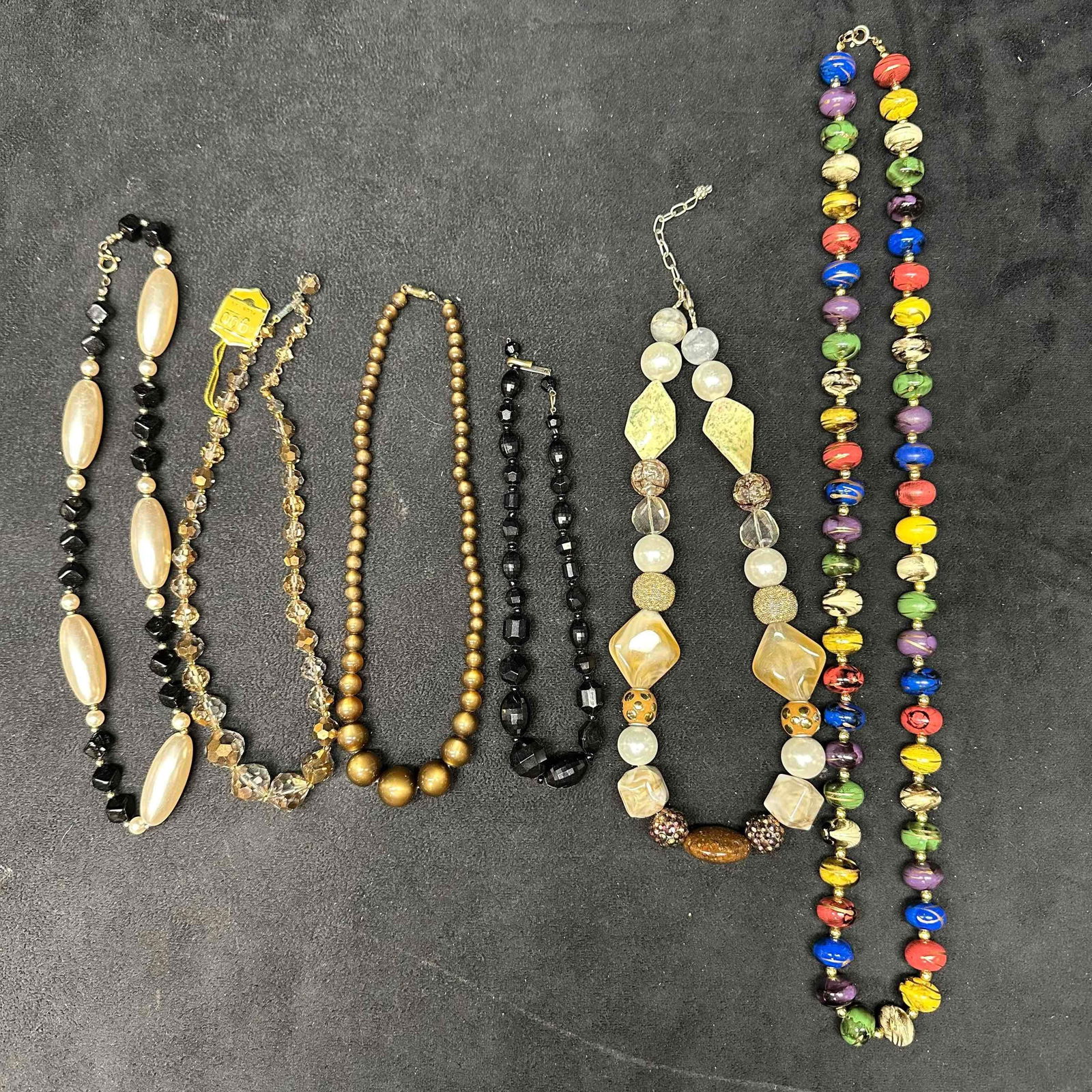 Lot of Beaded Costume Jewelry Necklaces Assorted Styles Designs K10: Grouping of six vintage costume necklaces featuring a mix of beaded and statement designs. Includes faux pearl strands, faceted crystal-style beads, metallic gold-tone glass beads, chunky black beads,