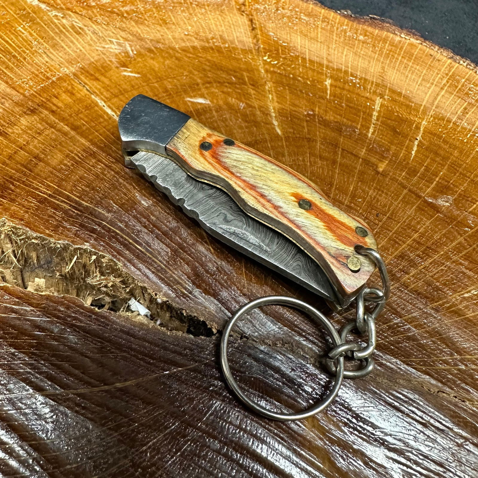 MHS Cutlery Keychain Steel Blade Pocket Knife Brown Orange R49: Small folding-blade pocket knife featuring a steel blade and a compact epoxy-resin/wood handle secured with brass pins. Includes an attached metal key ring for easy carry. Good like-new condition wit