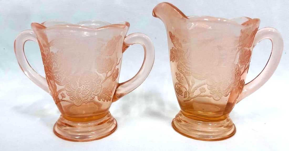 Royal Lace Pink Depression Cream & Sugar Glassware: This lot contains a Royal Lace Pink Depression Cream & Sugar Glassware. The Creamer is approx 4 1/2" x 3" x 4 1/2" while the sugar glass is approx 5" x 3 1/4" x 3 3/4" and together they weighs about 1