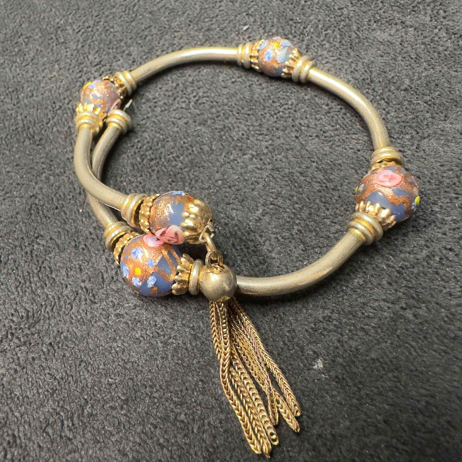 Venetian Murano Lamp Work Glass Art Purple Colored Beaded Bracelet Bangle Tassel F79: Venetian Murano Lamp Work Glass Art Purple Colored Beaded Bracelet Bangle Tassel F79. Flexible bracelet with purple colored glass beads with beautiful designs on each. The bangle is silver toned and h