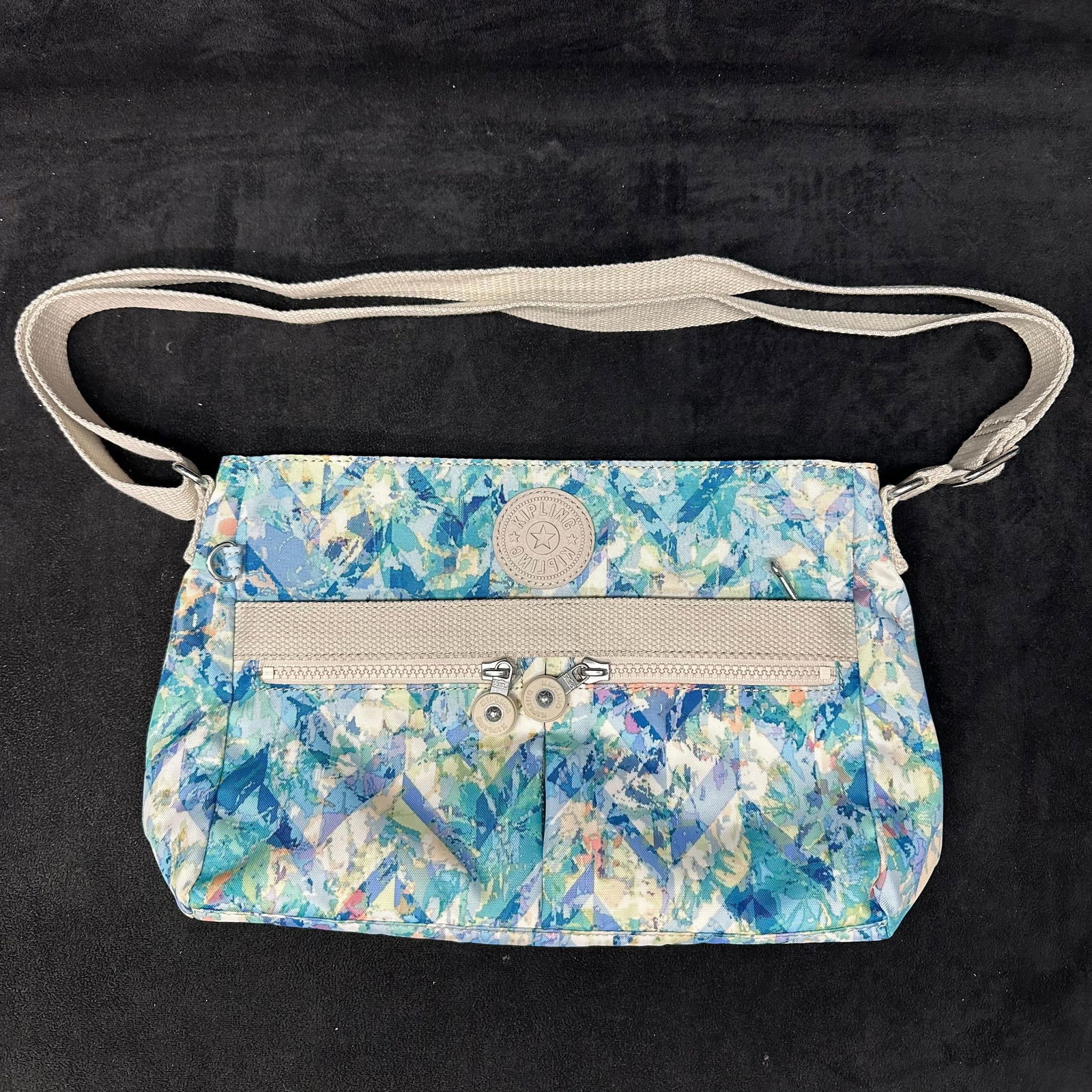 Kipling Angie Nylon Crossbody Shoulder Bag Blue Green White: Kipling nylon crossbody shoulder bag featuring a multicolor abstract pattern. Includes an adjustable fabric shoulder strap, zip-top closure, exterior zip pocket, and interior zip pocket with light-col