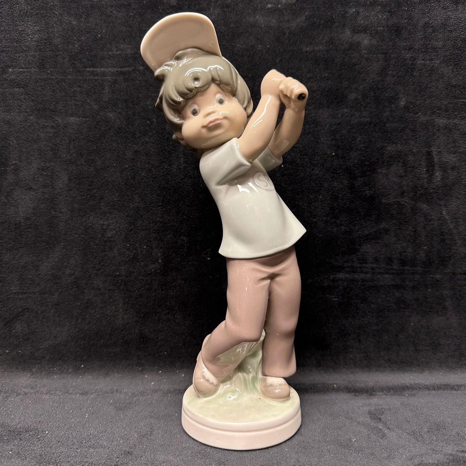 Lladro Sport Billy Boy Golfer Porcelain Figurine: Lladro porcelain figurine depicting “Sport-Billy” as a young boy golfer in mid-swing. Gloss-finish ceramic with soft pastel colors and detailed facial features. Marked on the underside Lladro