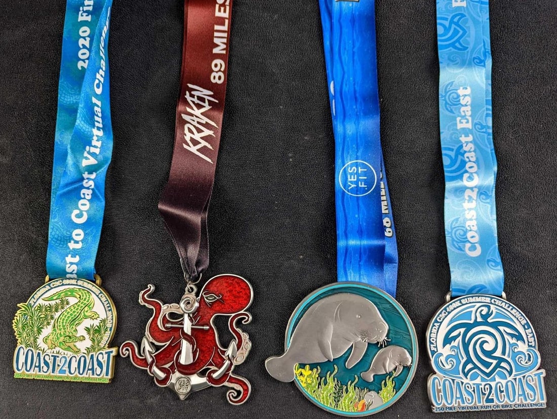 JB 4 Virutal Marathon Medals Kraken Manatee: This lot includes: (1) Kraken 89 Miles Yes Fit Medal. Is approx 4 1/4" x 20". (1) Manatees 68 Mile Challenge Medal. Is approx 4 1/2" x 19". (1) Florida Coast-2-Coast Vi