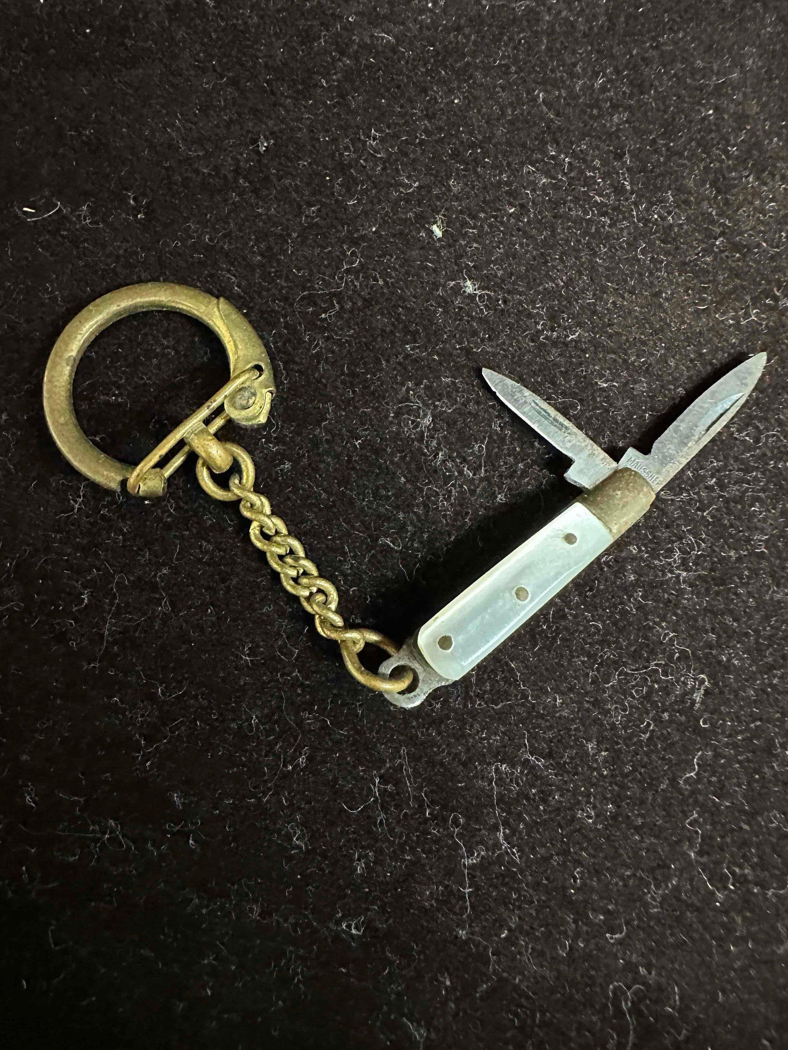 Two Blade Miniature Pocket Knife Maussner Germany Brass Tips Pearl Handle Mini Blade Keychain: Maussner Germany makers mark on the blade. Light rusting or discoloring green coloration on metal pieces on the knife, light patina, overall good condition. This item is in good pre-owned, previously