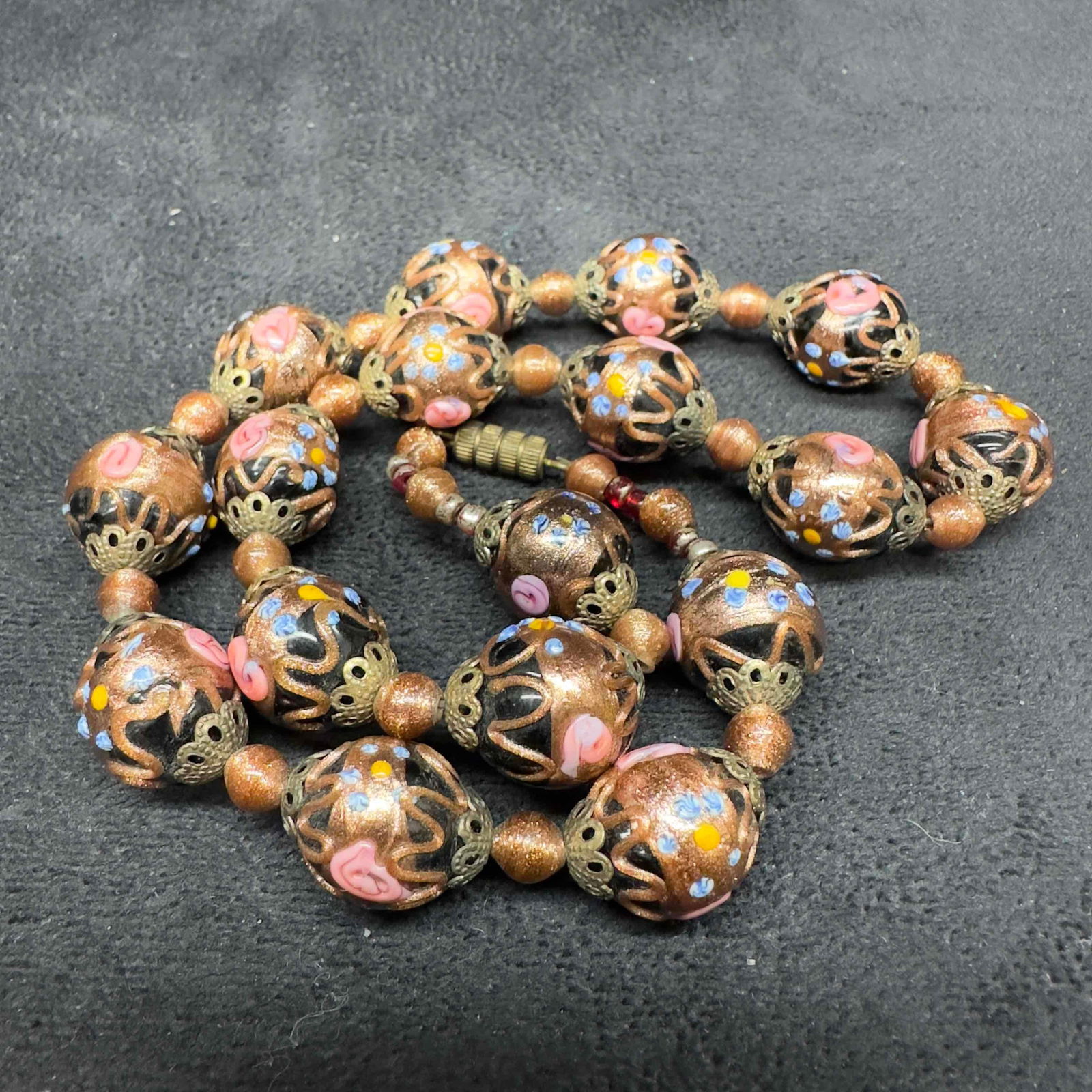 Murano Venetian Art Glass Lamp Work Bead Copper Floral Black Beaded Necklace B58: Murano Venetian Art Glass Lamp Work Bead Copper Floral Black Beaded Necklace B58. Necklace with black colored glass beads with beautiful designs on each. The necklace features floral and copper accent
