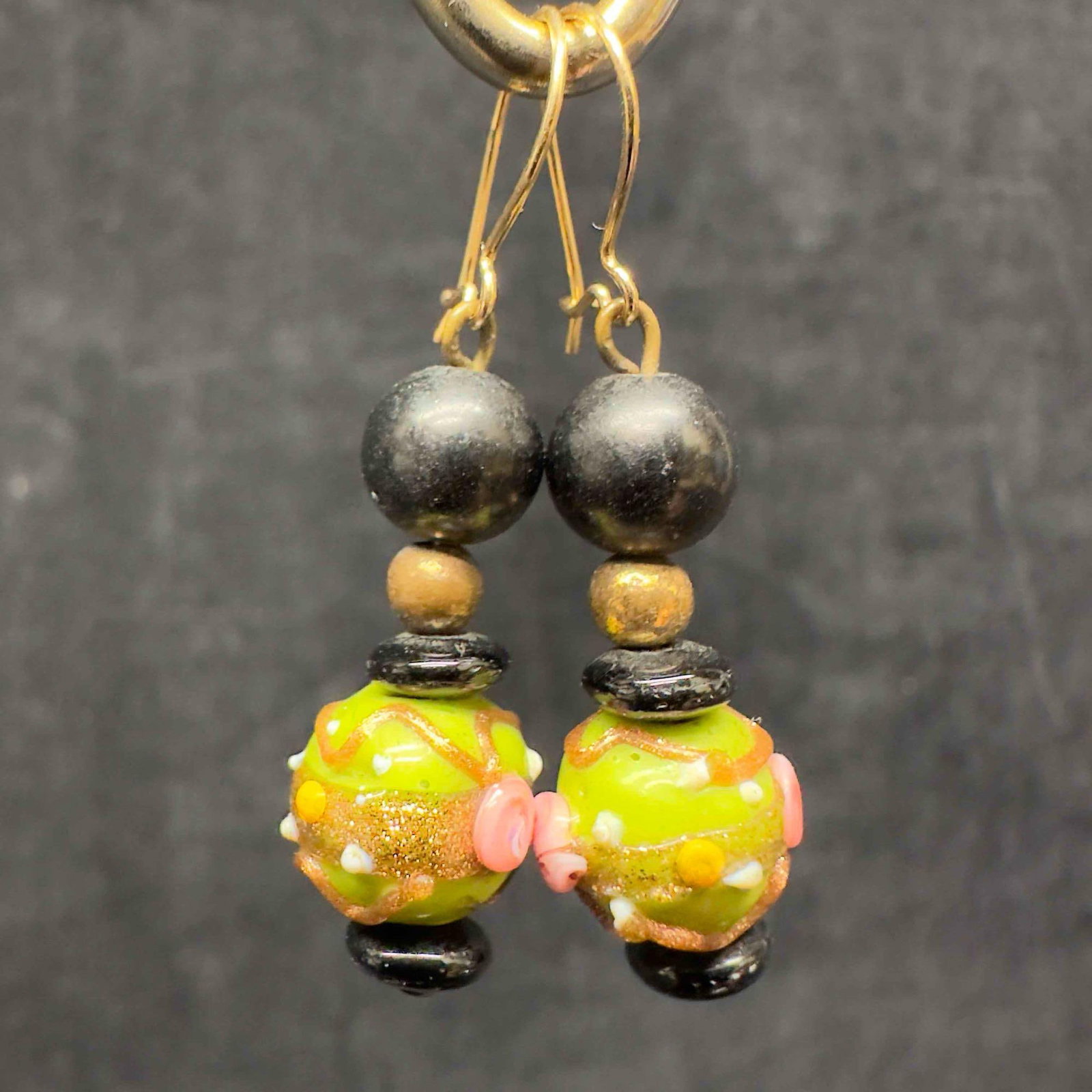 Murano Venetian Lamp Work Art Glass Green Round Beaded Black Accent Drop Dangle Earrings G97: Murano Venetian Lamp Work Art Glass Green Round Beaded Black Accent Drop Dangle Earrings G97. Earrings with green colored glass beads with beautiful designs on each. The earrings feature copper colore