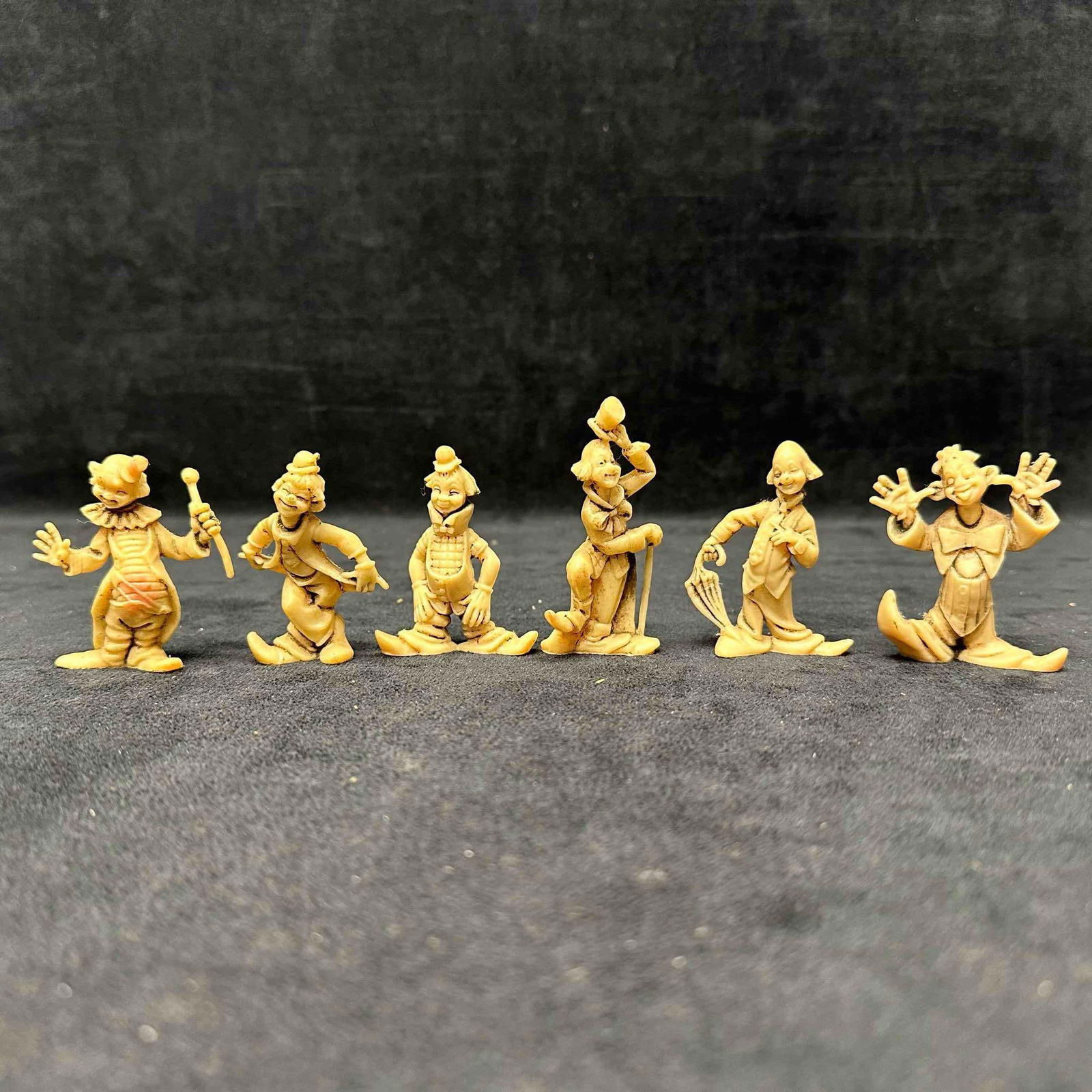 Set of Six Plastic Resin Clown Figurines Hong Kong: Set of six vintage plastic clown figurines, each with unique poses and expressions. Made in Hong Kong, mid-20th century. Figures show light wear and some discoloration consistent with age. These items