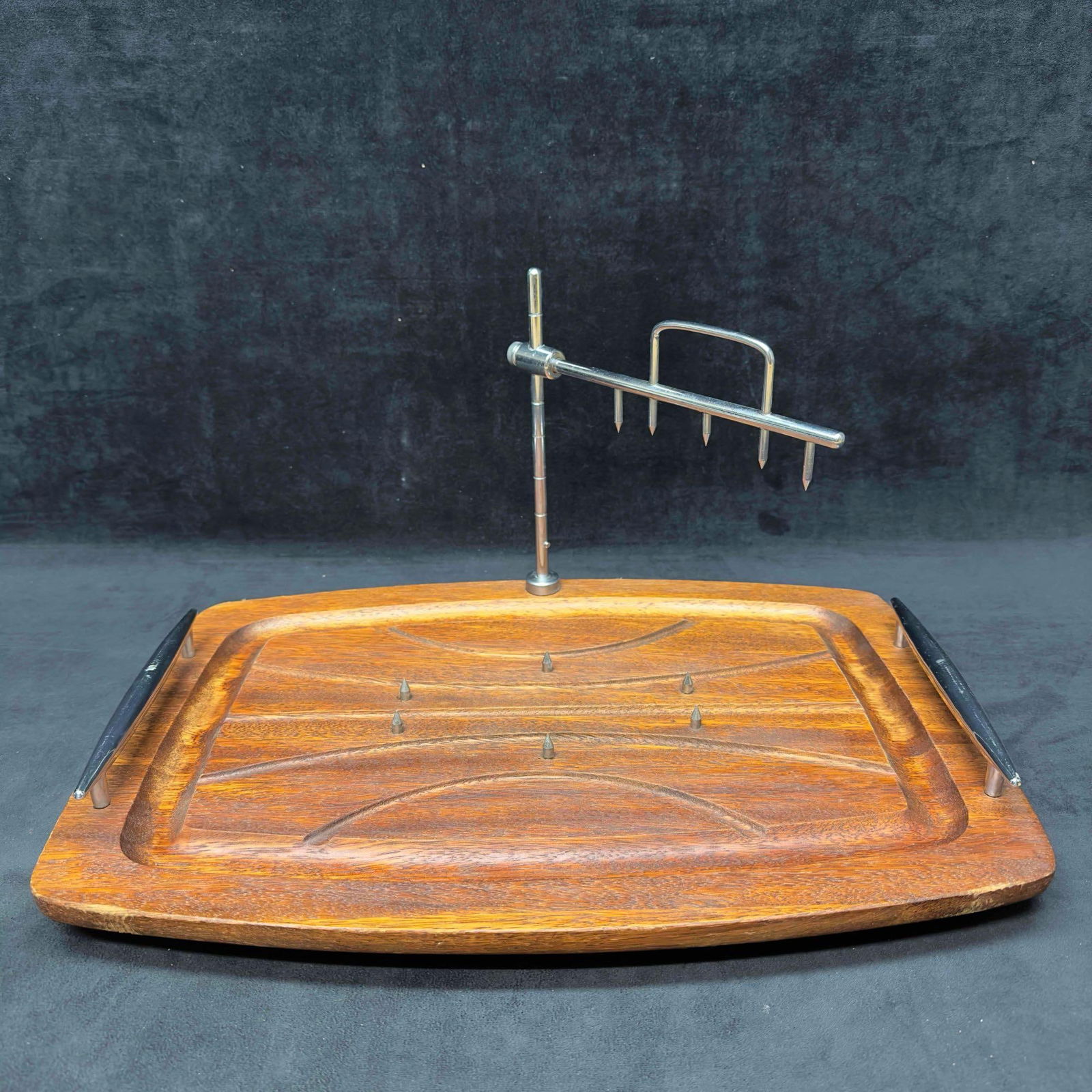Vintage Wood Meat Carving Board Tray with Spikes and Spiked Holder Attachment: Vintage Wood Meat Carving Board Tray with Spikes and Spiked Holder Attachment. This vintage cutting board is crafted from high-quality wood, it features a dark brown color with stainless steel handles