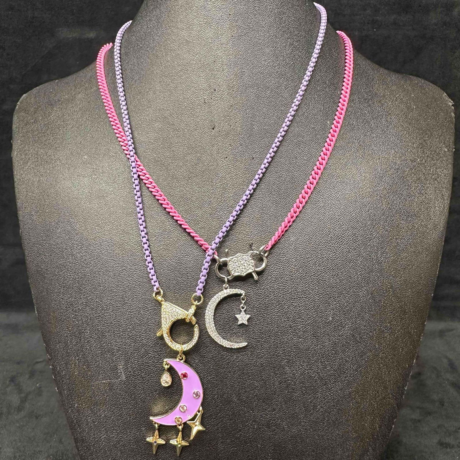 Pink Purple Chain Melania Clara Assorted Necklace Rhinestone Locket Moon Set: The Melania Clara necklace set features a magnet clasp closure. The necklaces have magnet extender clasp closures. Each necklace showcase modernist designs. Silver and gold tone accents. These items a