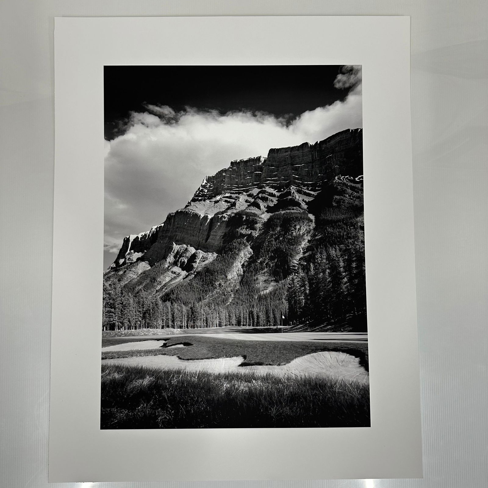 Black and White Landscape Photograph Print Mountain and Golf Course Scene Large Format C: Large format black and white photography print showing a dramatic mountain range rising above a golf course. The image features strong contrast, detailed texture, and balanced composition. Printed on