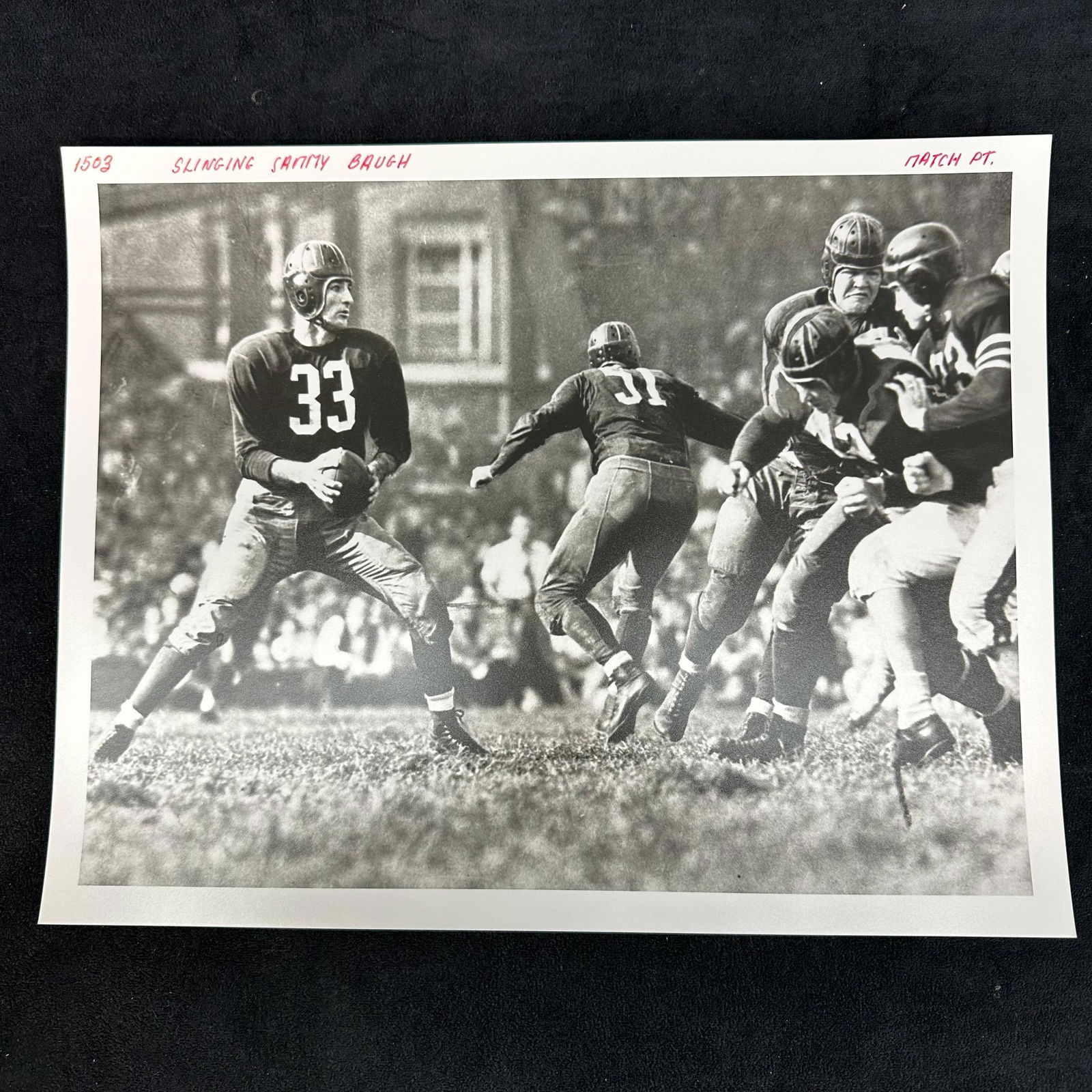 1940's Football Silver Gelatin Print Slingin Sammy Baugh Action Shot: Black-and-white analog photo print depicting Hall of Fame quarterback “Slingin’” Sammy Baugh (#33) mid-play, surrounded by teammates and defenders during a classic 1940s NFL game. Hand-label