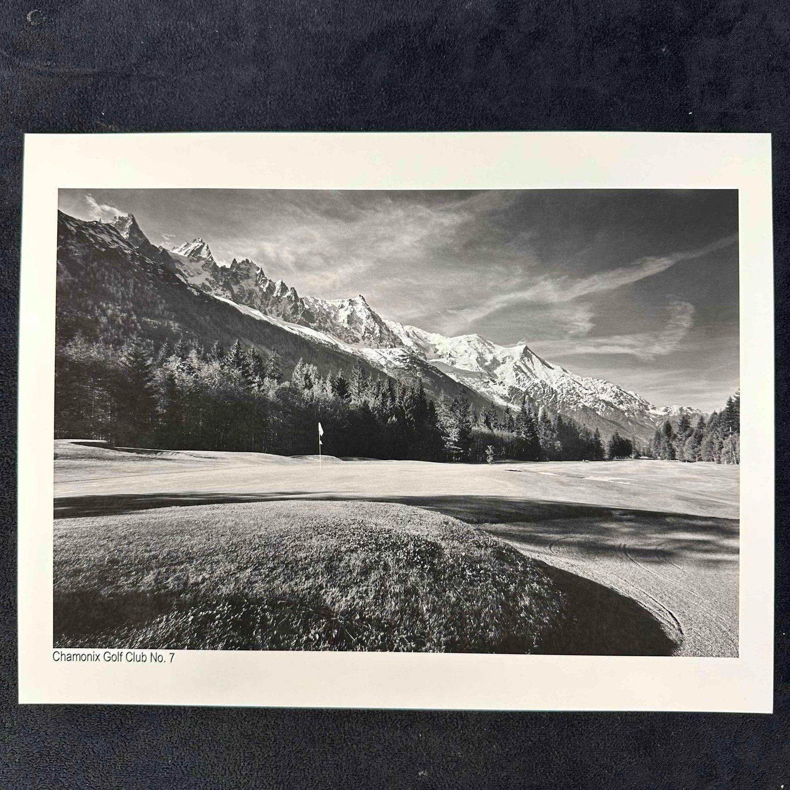 Chamonix Golf Club No. 7 Black & White Landscape Photo Print: Black and White print of Chamonix Golf Club hole No. 7, showcasing a sweeping view of the golf course set against the dramatic backdrop of the French Alps. This item is in good pre-owned, previously d