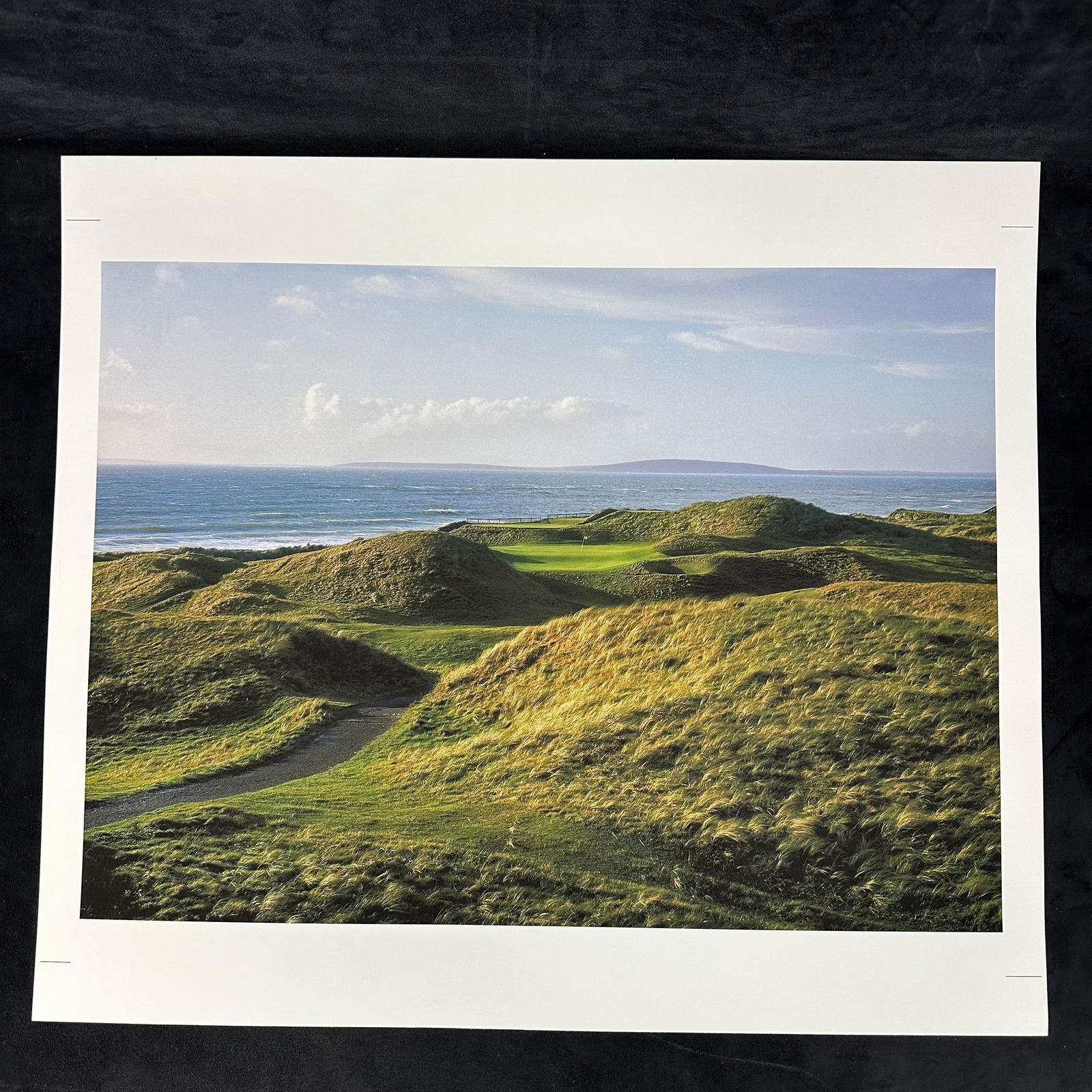 Inkjet Color Photography Print Coastal Links Golf Course Landscape: Vivid color inkjet photograph depicting a breathtaking coastal links golf course, with rolling dunes of golden grass leading out to the deep blue ocean. The flag is visible in the distance, framed by