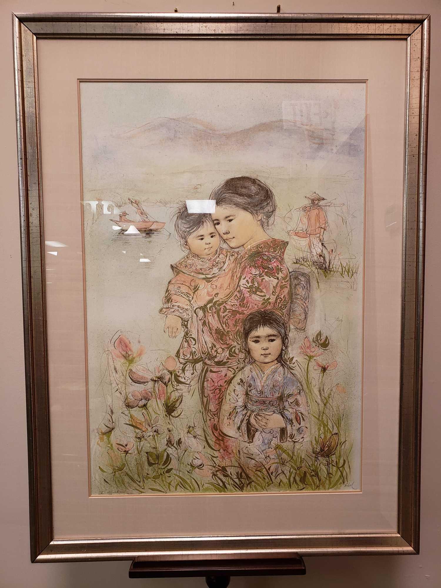 Edna Hibel Family of the Mountain Lake Signed Lithograph: Edna Hibel Family of the Mountain Lake Signed Lithograph. This work is in excellent condition. The lithograph is nicely framed in a modern silver colored wood frame. The lithograph comes with a certif