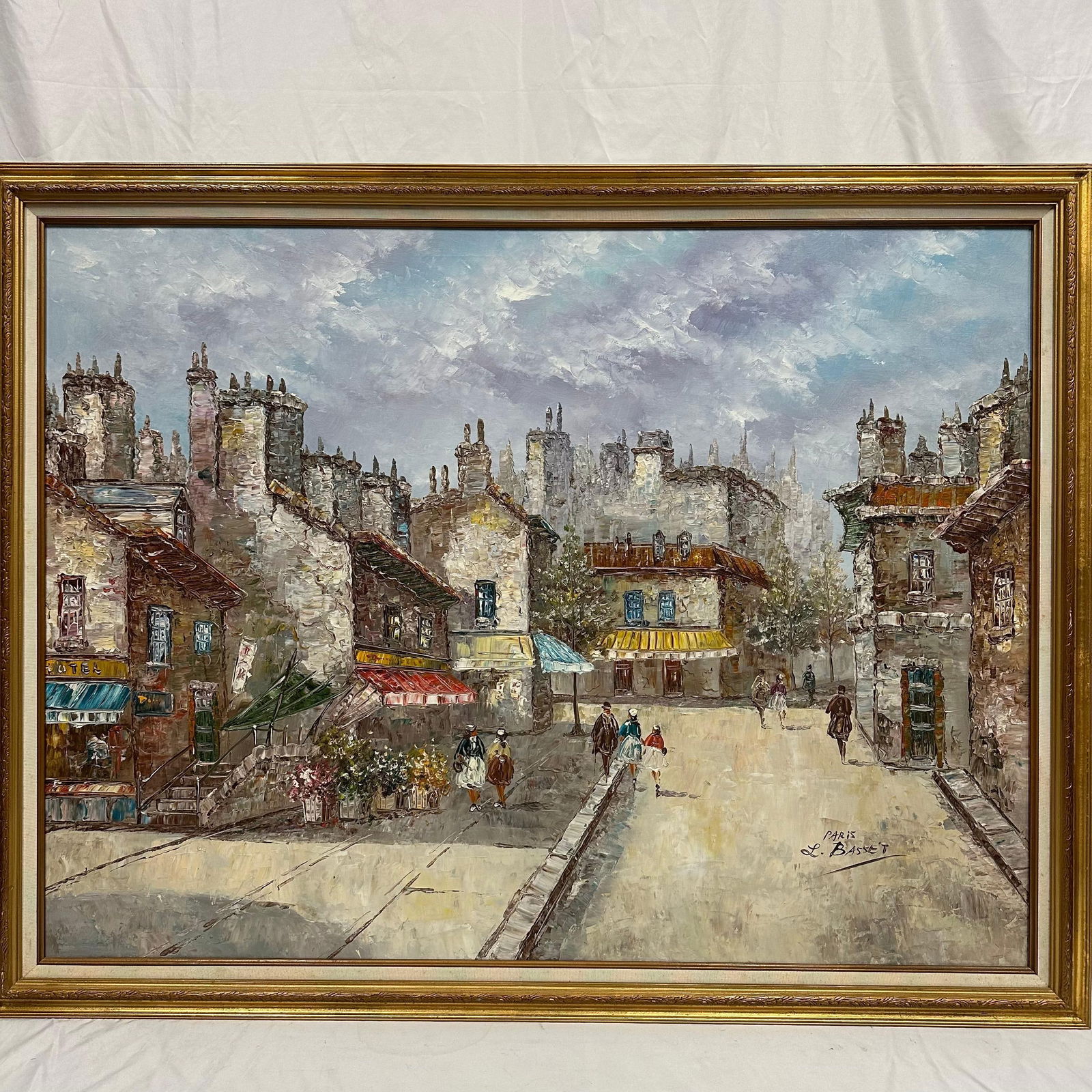 Large Original Oil Painting on Canvas framed Paris Street Scene Signed L. Basset: Large vintage oil-on-canvas painting depicting a Paris street scene with shops, still figures, and tall historic buildings. Signed L. Basset at the lower right-hand corner. The artwork features a heav
