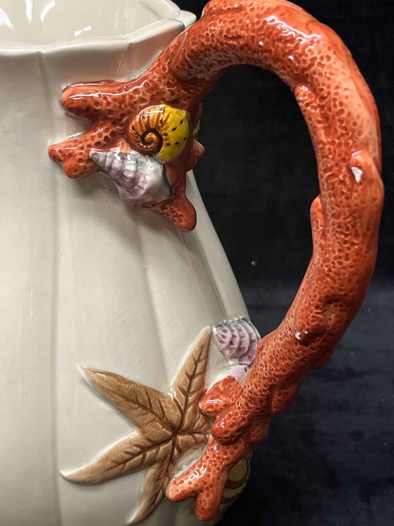 Fitz & Floyd Coral/Shells Pitcher: This lot contains a Fitz And Floyd Coral Shells Pitcher. It is approx 8 1/2" x 4 1/2" x 10". Total weight is approx 2.2lbs. Overall the Fitz and Floyd pitcher is in good pre owned condition with some