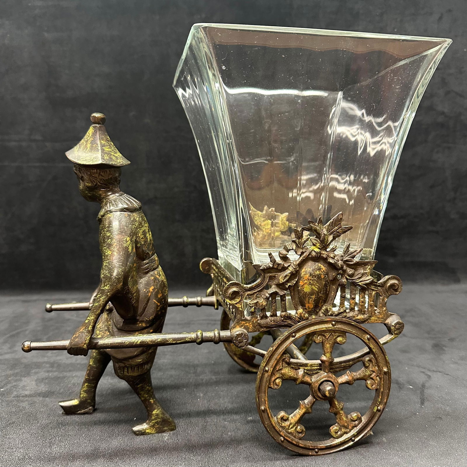 Castilian Imports Metal Rickshaw Planter with Glass Insert Made in India: Decorative cast metal rickshaw planter featuring a figural rickshaw puller with ornate wheeled cart. Includes removable square clear glass insert bearing Castilian Imports mark. Labeled Castilian 0910