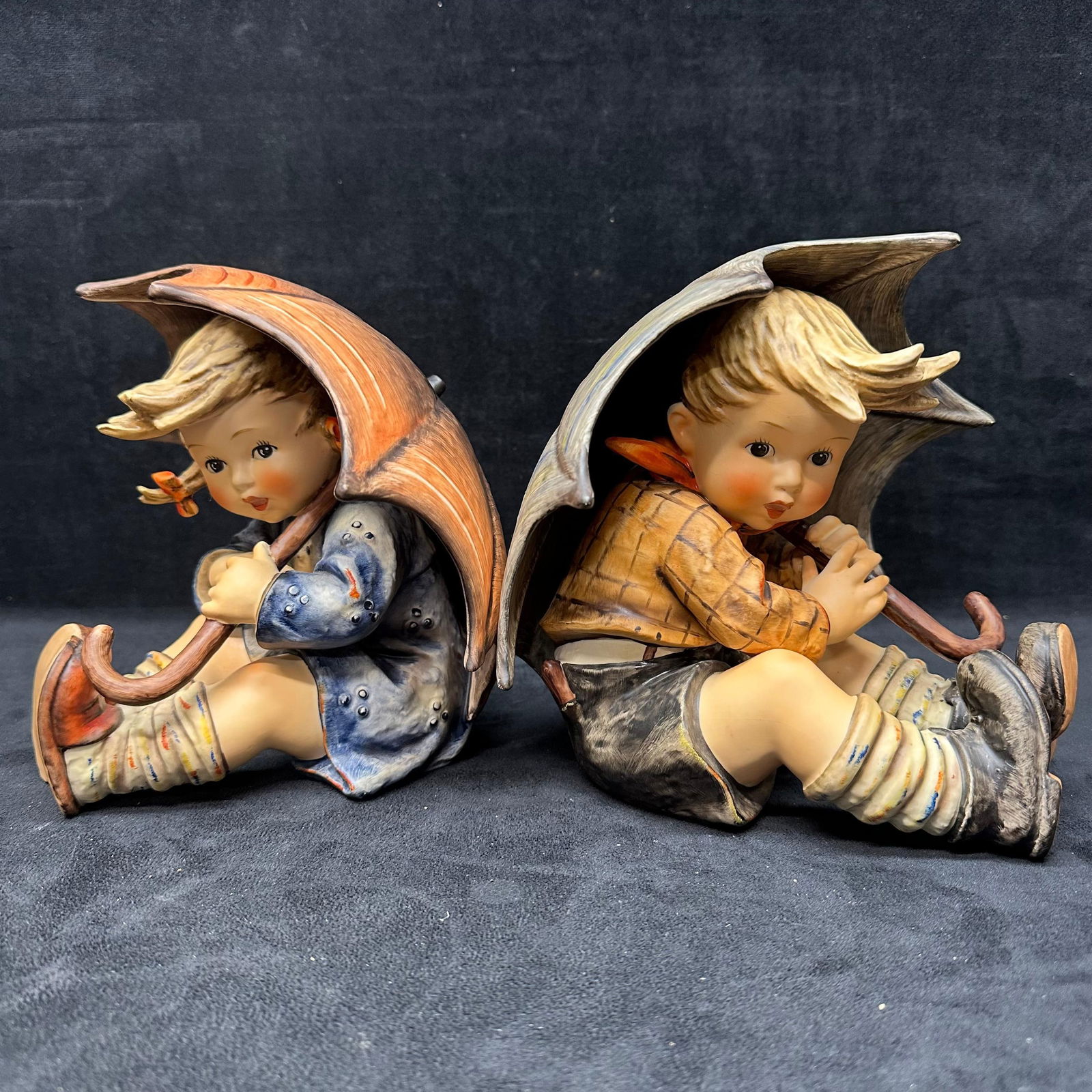 Goebel Germany Umbrella Boy and Girl Figural Set Hummel Figures 152AB: One figure has a small break, a chip on the left side of the umbrella of the girl figure. Missing piece. Each piece is marked underneath with the Goebel hallmark. These items are in good pre-owned, pr