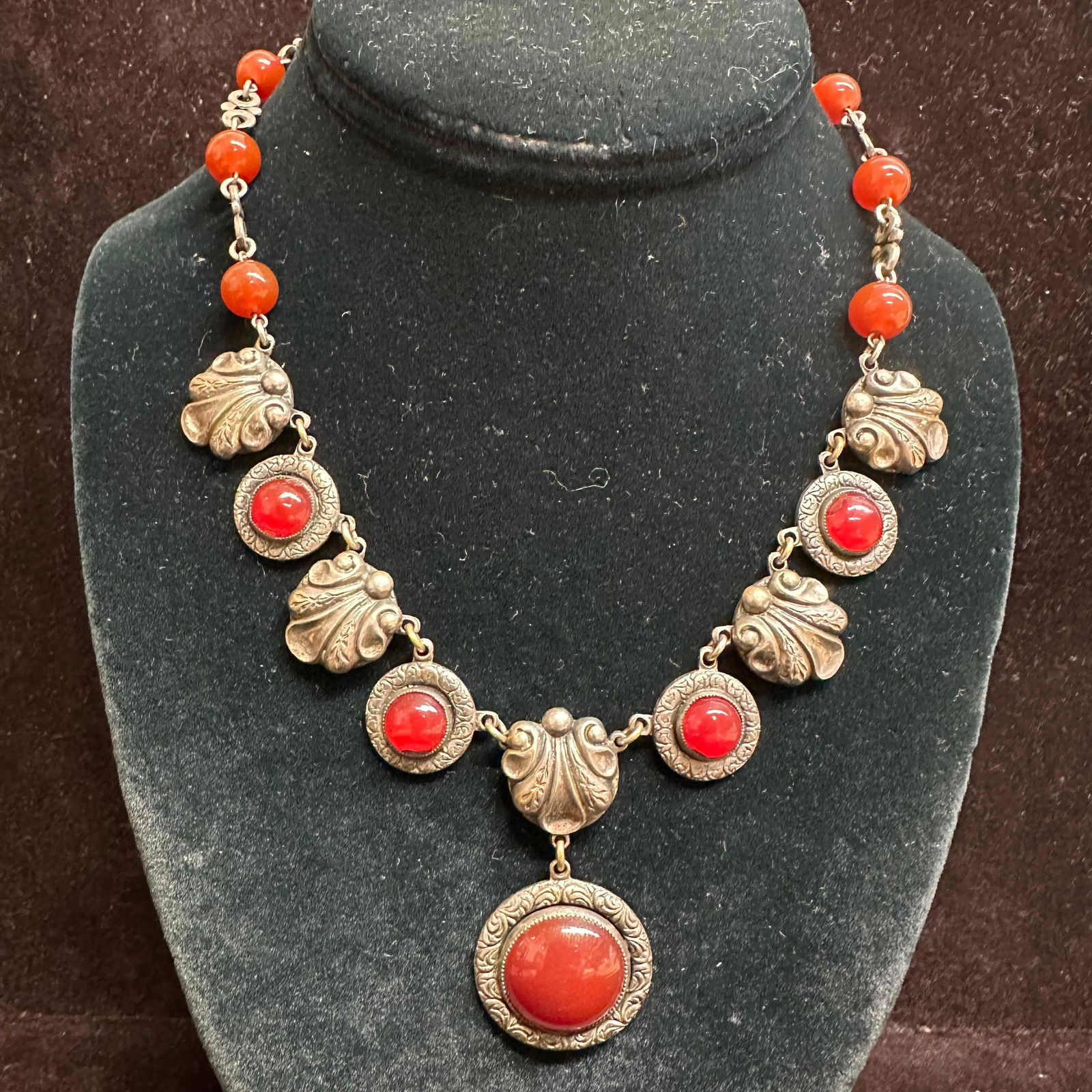 Vintage Silver-Tone Carnelian Necklace with Ornate Settings: Vintage necklace featuring multiple round cabochon stones in a rich red-orange hue, consistent with carnelian, set in ornate silver-tone bezels. Necklace design alternates between smooth round cabocho