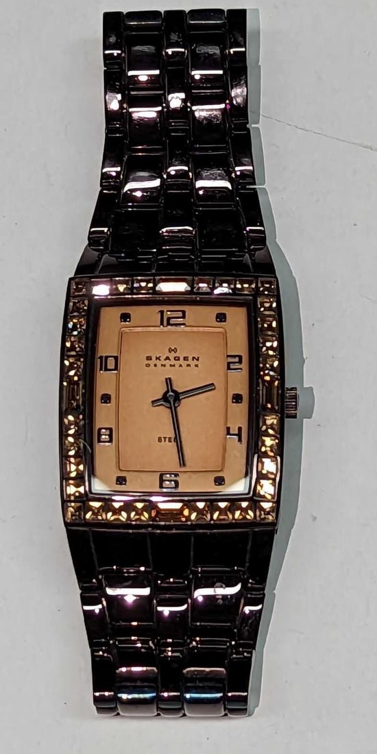 Ladies Skagen Steel 527SMX Crystal Bezel Watch: Ladies Skagen Steel 527SMX Crystal Bezel Watch. Requires a new battery. This is approx 1" x 1/2" x 3 1/4" and it weighs 0.17lb. There is some signs of wear. Movement: Quartz (Battery) Wa