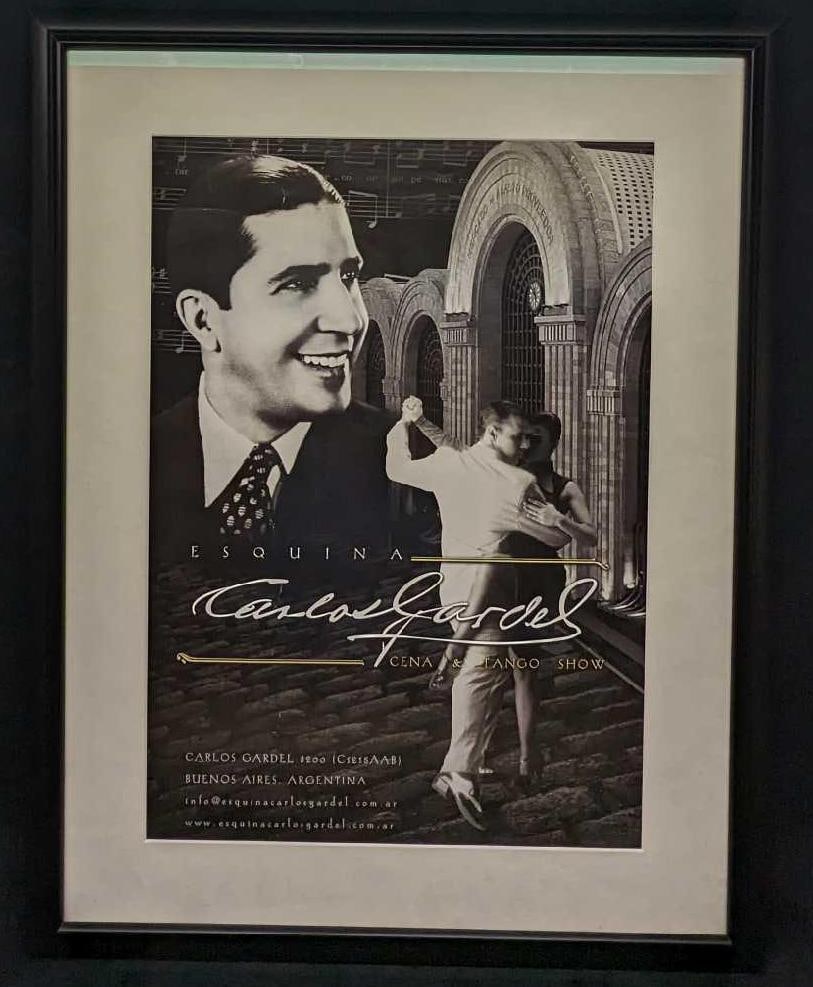 Esquina Carlos Gardel - Cena & Tango Show Poster: Esquina Carlos Gardel - Cena & Tango Show Poster. This framed poster is approx 26" x 1" x 33 1/2" and it weighs 8.70 lbs. There are some wrinkles near the top left of the poster and chips on the frame