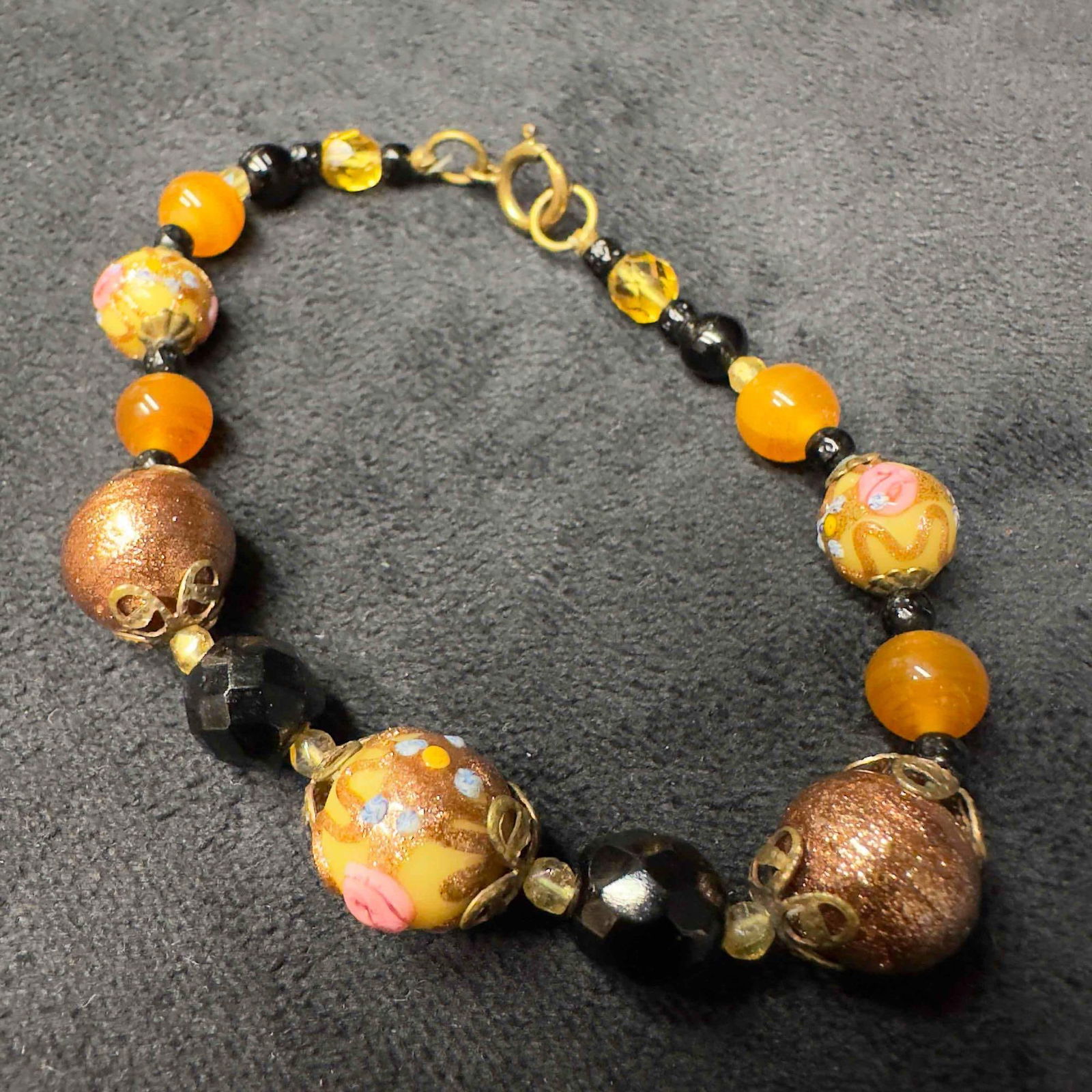 Venetian Murano Lamp Work Glass Art Cream Copper Colored Beaded Bracelet H41: Venetian Murano Lamp Work Glass Art Cream Copper Colored Beaded Bracelet H41. Bracelet with multiple colored glass beads with beautiful designs on each. The bracelet features a spring ring clasp closu