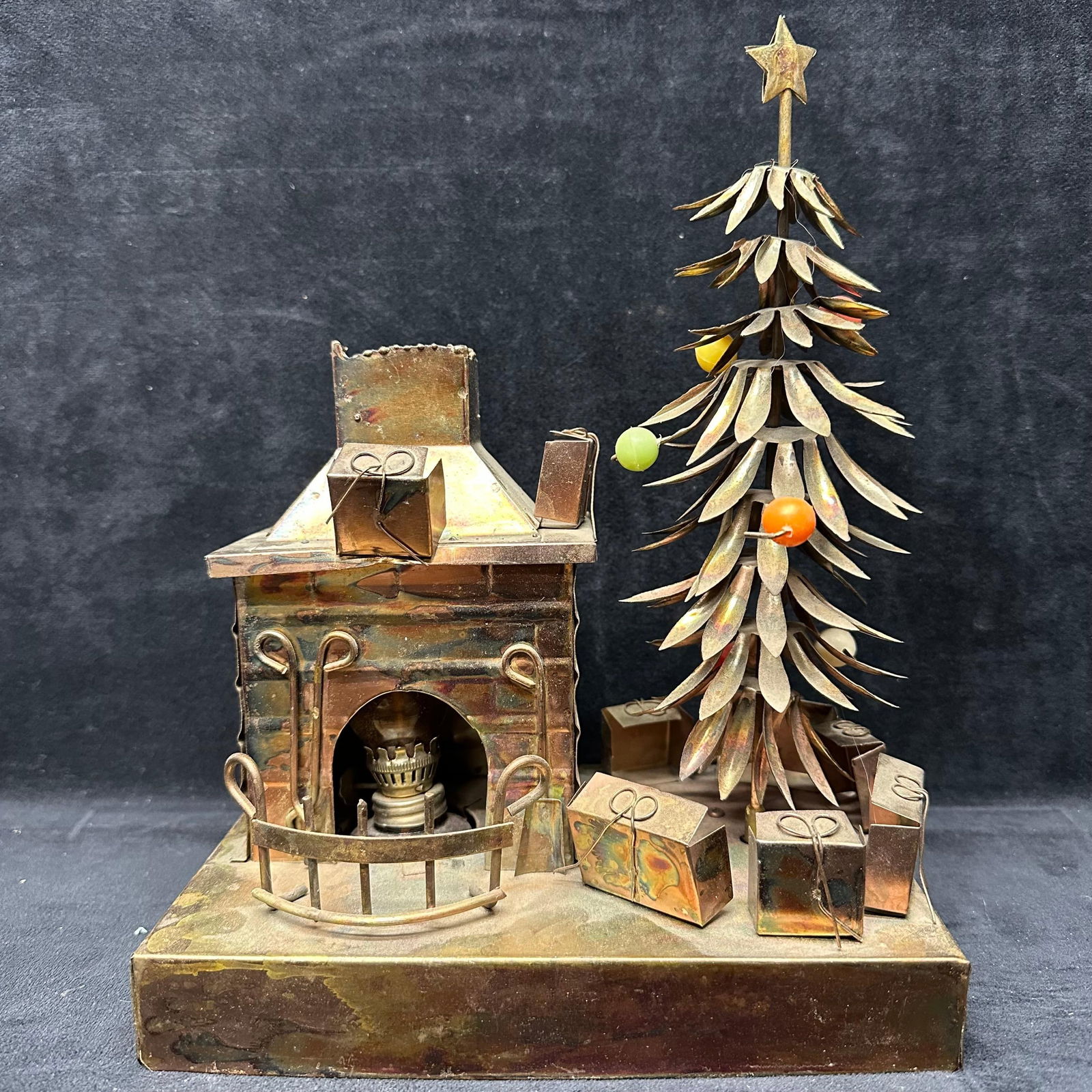 Music Box Metal Brass Sankyo Merry Christmas Tree Fireplace Glass Oil Lamp Light Diorama: Decorative metal Christmas music box diorama featuring a brick-style fireplace, stylized Christmas tree with star topper, wrapped presents, and removable amber glass oil-style lamp shade. Marked Sanky