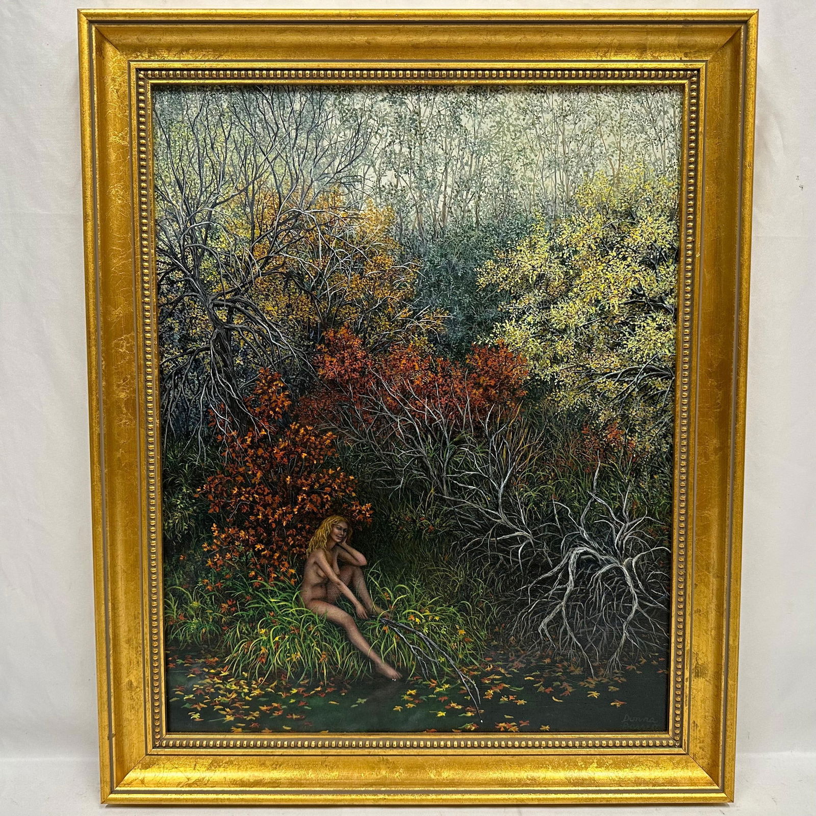Donna Bassett Original Oil Painting Nude Woman in Autumn Forest Framed Artwork: Original oil painting by artist Donna Bassett, featuring a nude woman seated along the edge of a woodland stream surrounded by rich autumn foliage. The scene is highly detailed, with intricate brushwo