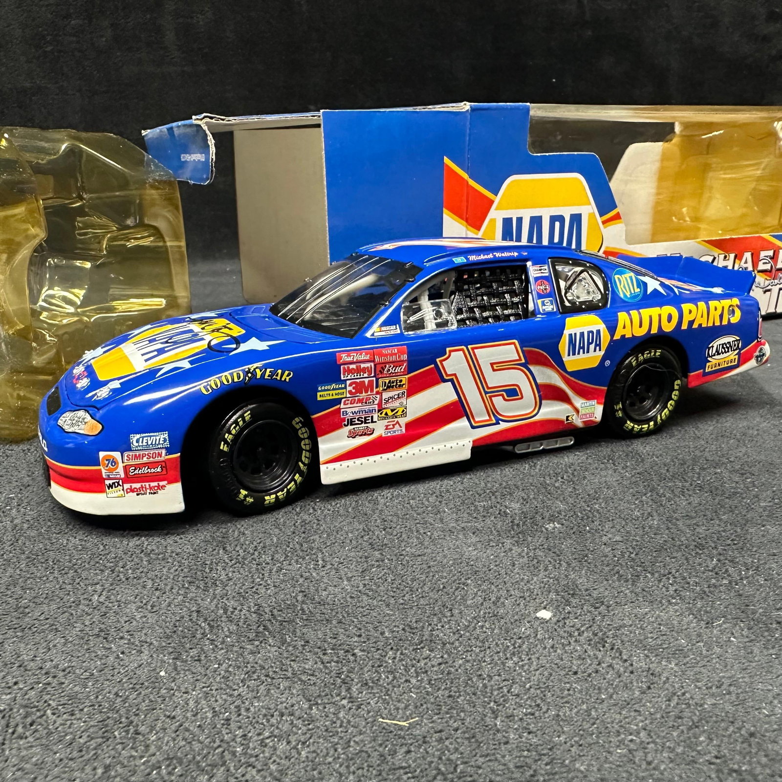 NAPA Racing Chevrolet Monte Carlo 1:24 Diecast Patriotic Car Michael Waltrip Signed: Limited edition 1:24 scale NASCAR diecast featuring Michael Waltrip’s #15 NAPA Racing Chevrolet Monte Carlo. The car is hand-signed on the hood by Michael Waltrip in black marker. Produced by Action